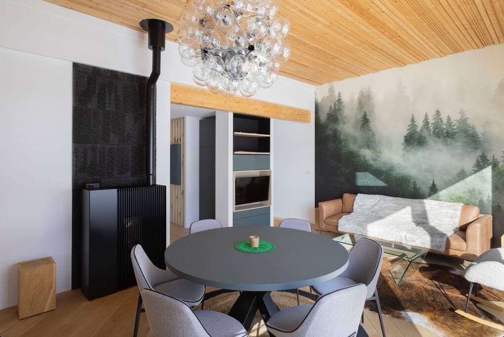 Salon lumineux avec grandes fenêtres offrant une vue imprenable sur la station de ski.