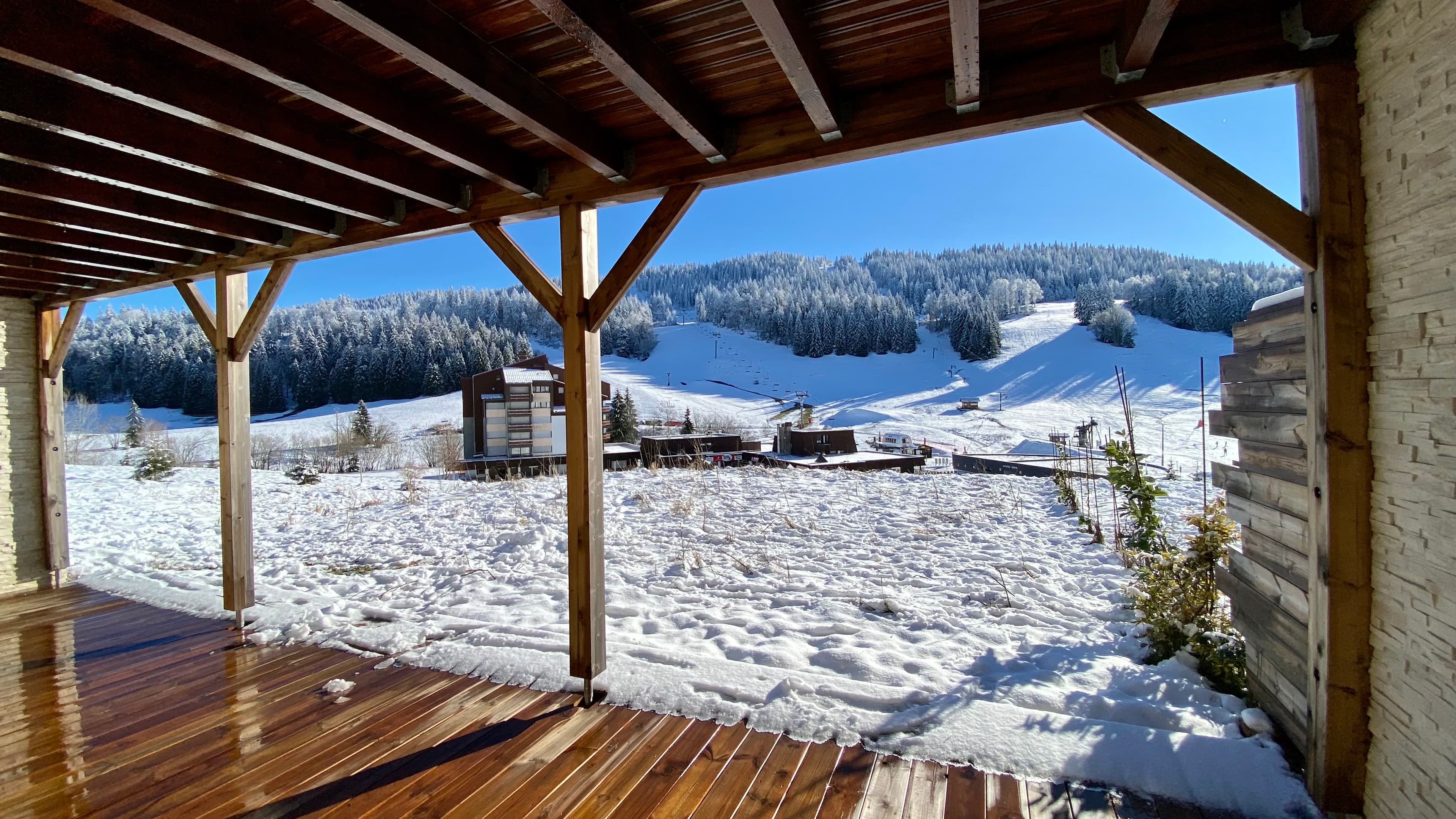 Chalet avec terrasse équipée de chaises longues, idéale pour se détendre au soleil.