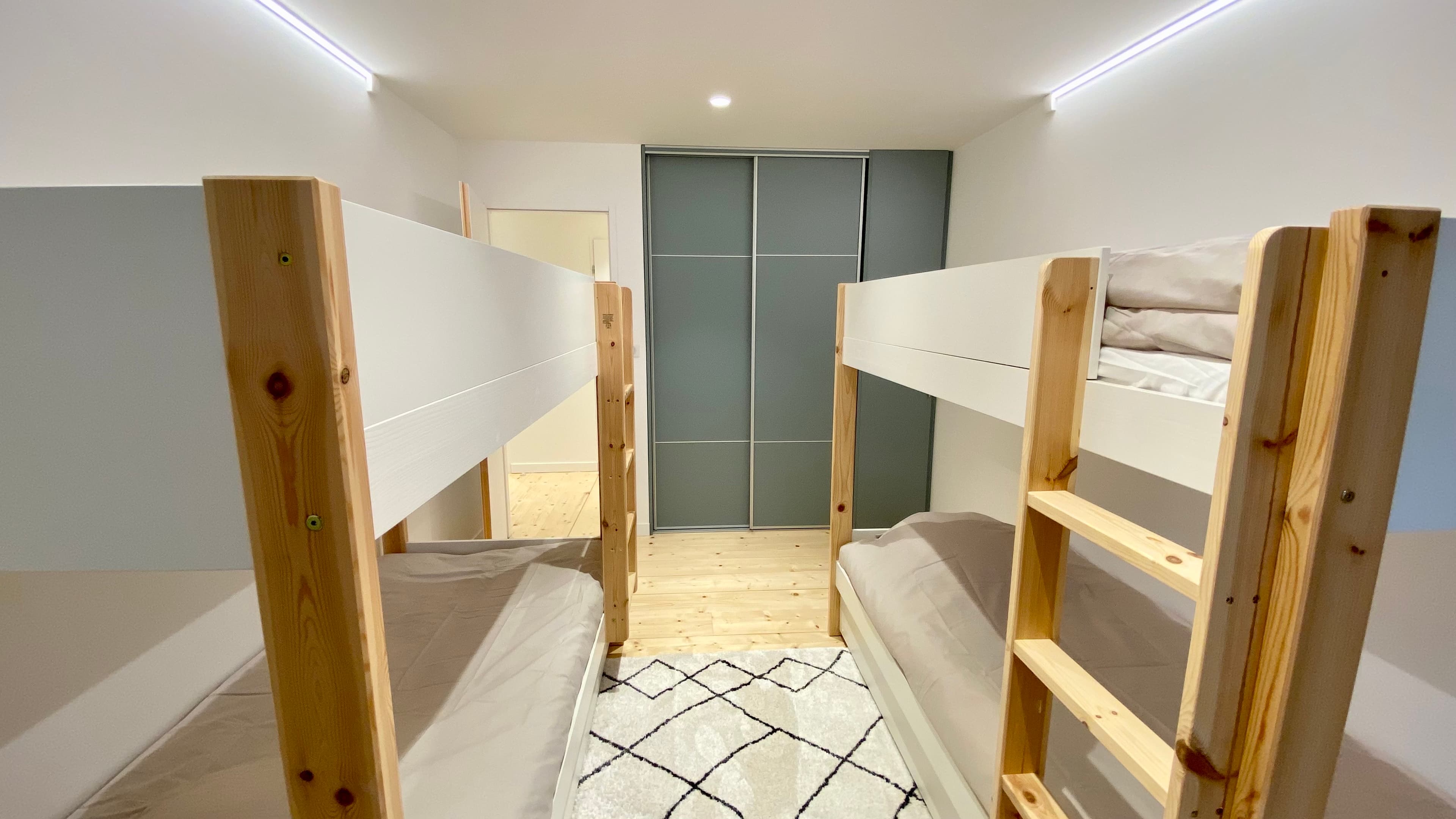 Espace nuit optimisé avec 4 couchages superposés, idéal pour les familles nombreuses.