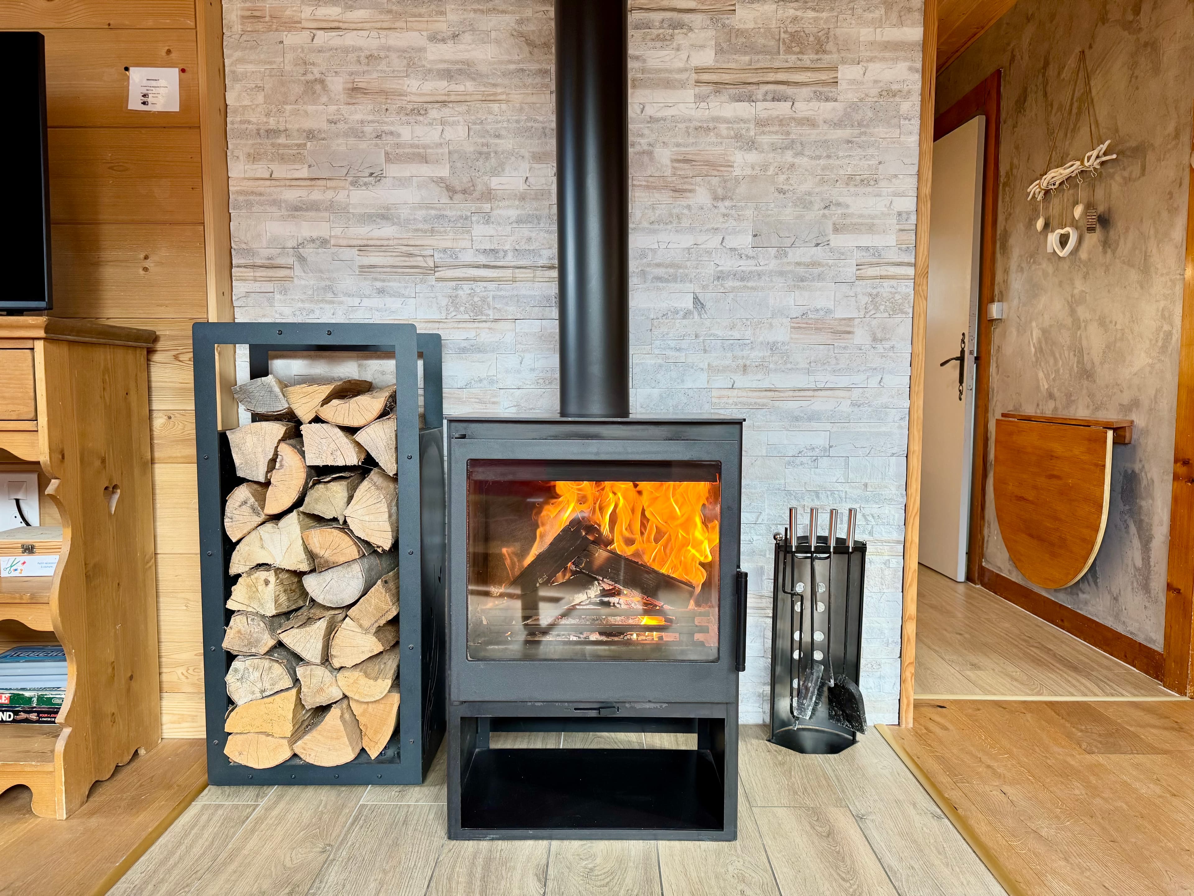 Poêle à bois dans le chalet aux Rousses, créant une ambiance chaleureuse et confortable.