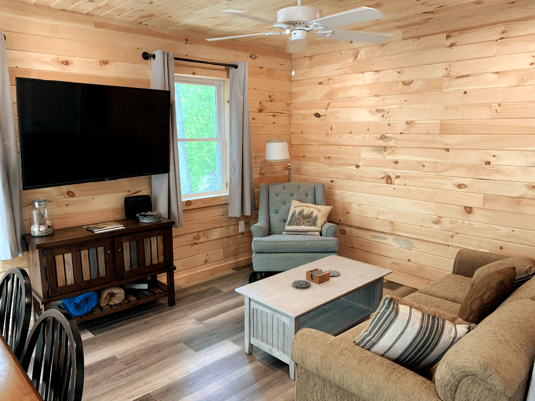 Comfy Living with 55" Flatscreen and queen sized sofa bed. A curtain can be drawn for privacy.