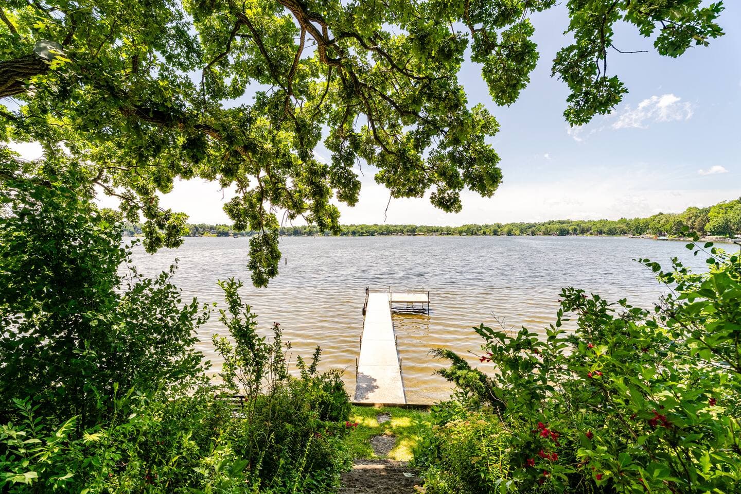 Summertime view from backyard to Bohner's lake.  Yes, we offer a sandy bottom lakefloor with access to private pier.