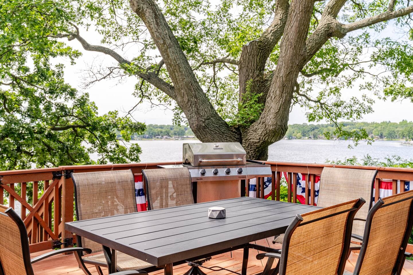 We offer a propane grill and seating for six at dining table on deck overlooking lake.