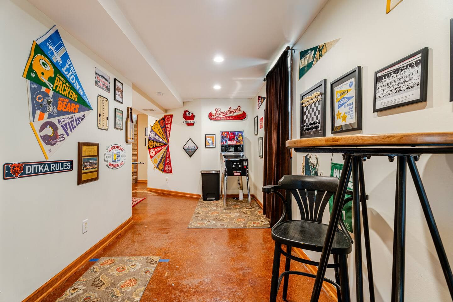 Gameroom! Video pinball, dartboard, wall chess set, and  stained concrete flooring highlight this photo where the theme is Chicago sports meets Milwaukee sports.
