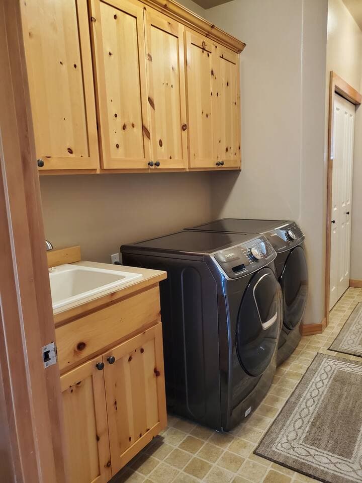 Laundry room with front loading washer and dryer, complete with some laundry pods and dryer sheets.  You'll also find folding chairs, boot dryer, broom, and vacuum.