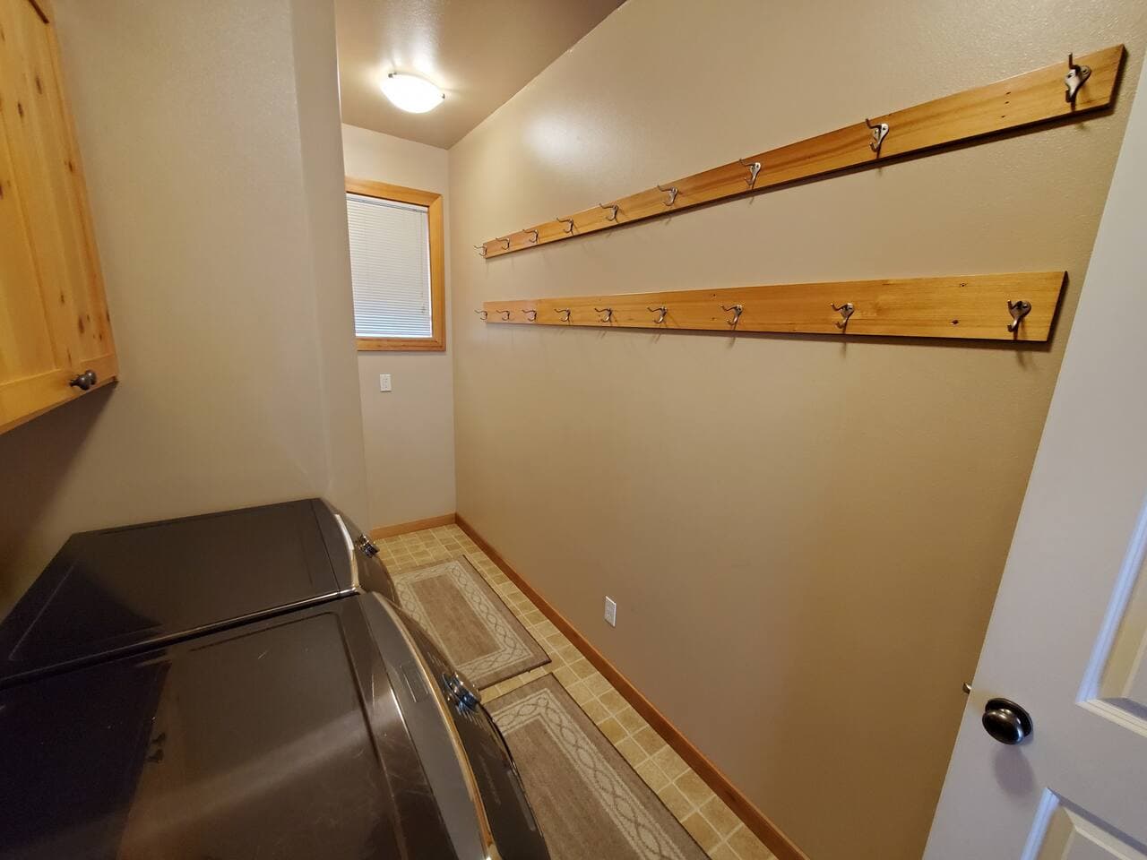 Laundry room has ample hooks for hanging up coats, snow pants, and bags.