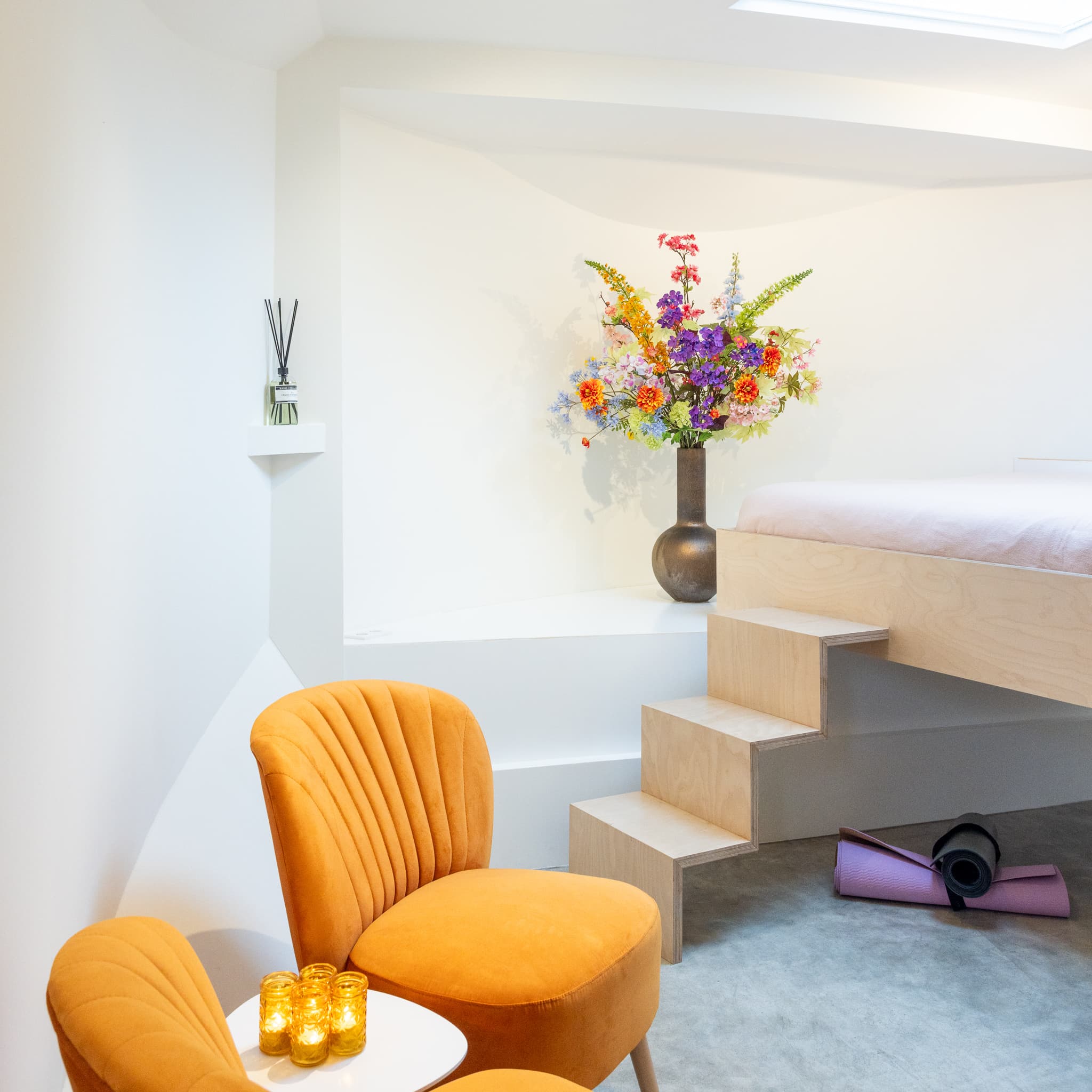 Our cosy living with comfortable bed, flowers, yoga mat and seating area - Houseboat Amsterdam BB