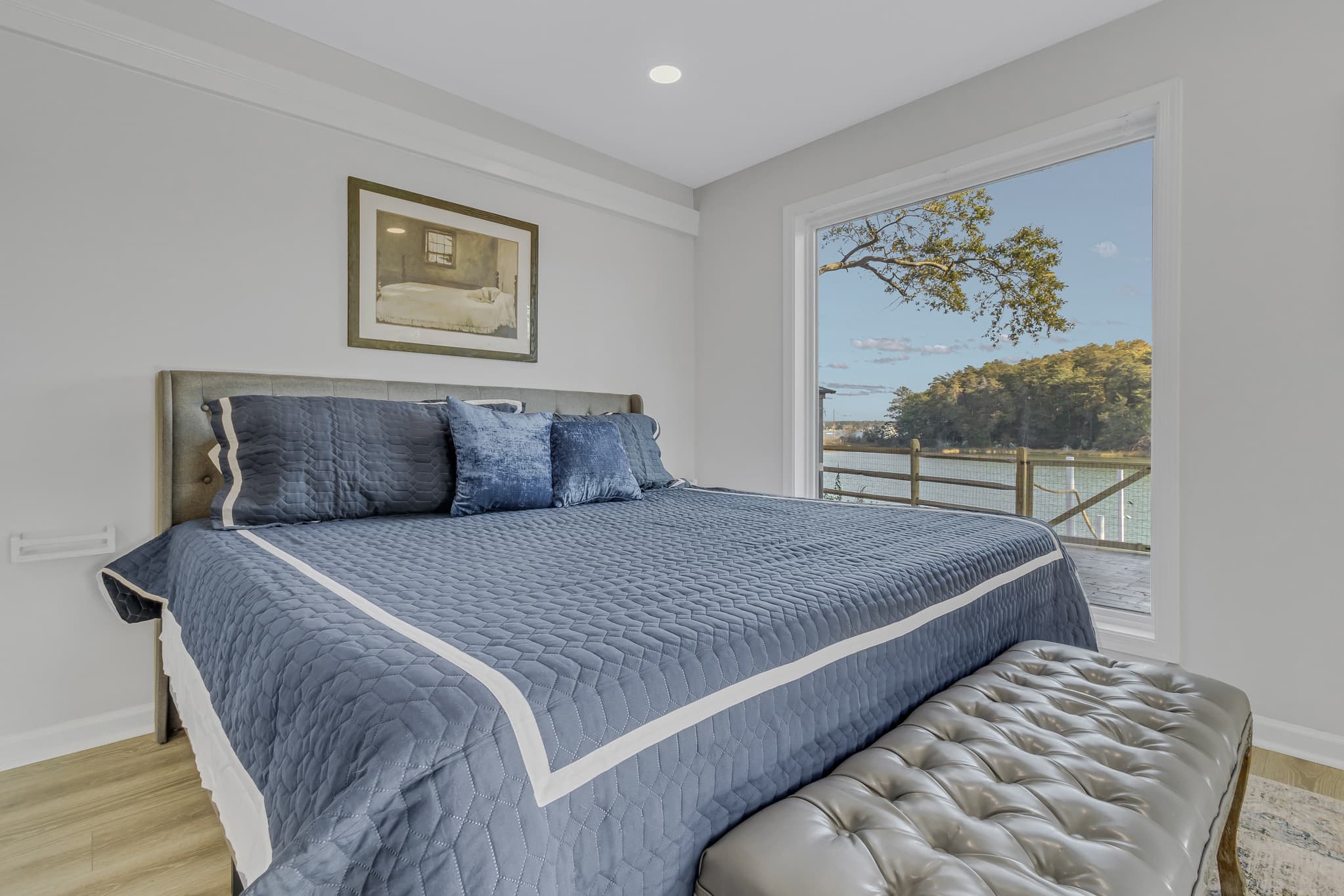 King bed with water view. Device charger next to bed.