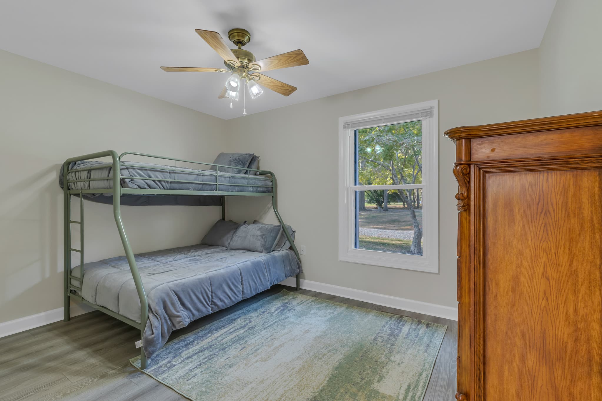 Full/twin bunk with view of the front yard.