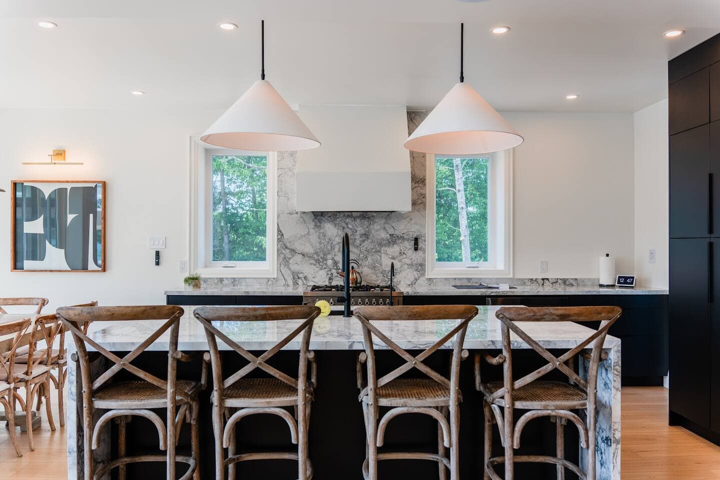 Spacious kitchen with a walk-in pantry, sleek black cabinetry, quartz countertops, and a custom micro-cement range hood.