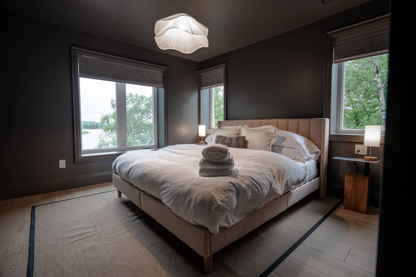 King sized bed in a dark themed room featuring a closet. 