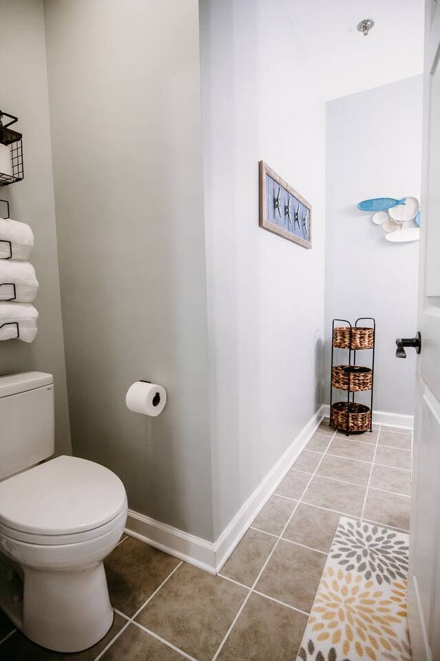 This private full bathroom is conveniently attached to the master bedroom and features a clean, coastal design with a shower/tub combo, soft towels, and plenty of storage space—perfect for families or groups.

