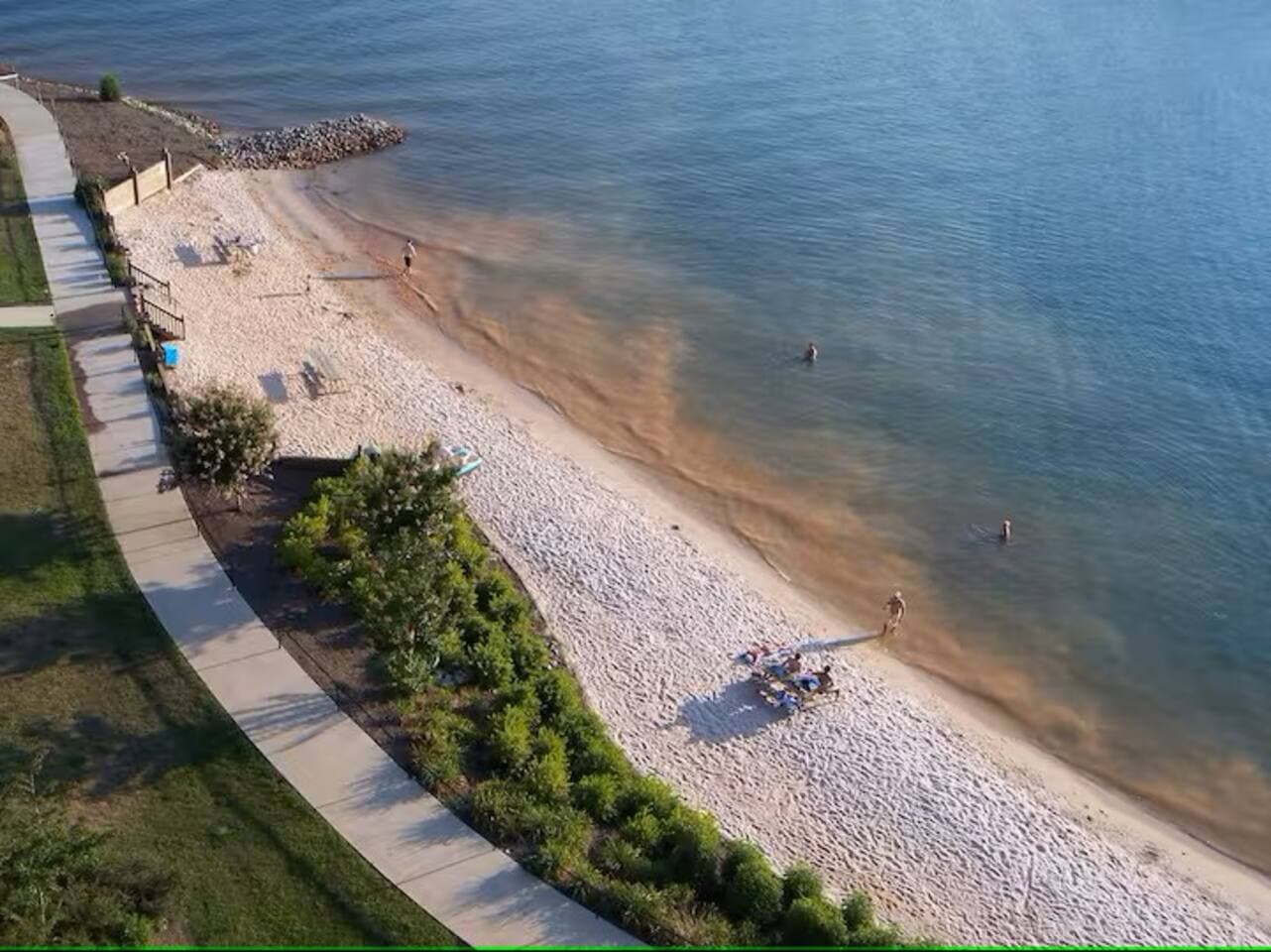 Relax and soak up the sun just steps from the condo at the private community beach along the lake. Perfect for swimming, lounging, or evening strolls with stunning waterfront views!

