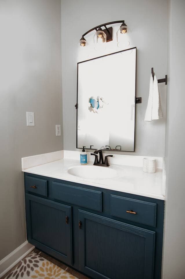 This stylish full bathroom features a modern vanity with ample counter space, rich blue cabinetry, and updated fixtures. Bright lighting and a large mirror provide the perfect setup for getting ready with ease. Hairdryer provided in each bathroom.

