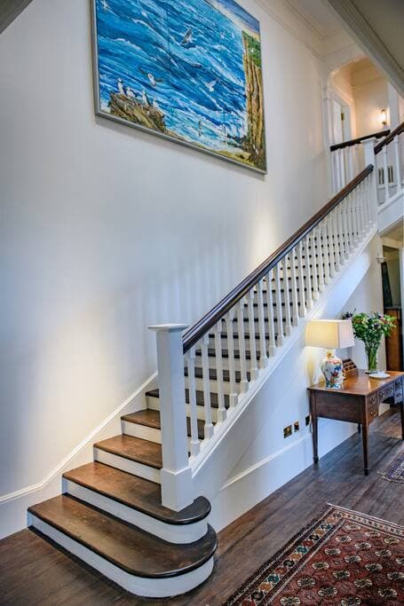 Main staircase with painting of the view from Peedie Sands - our beach on the estate
