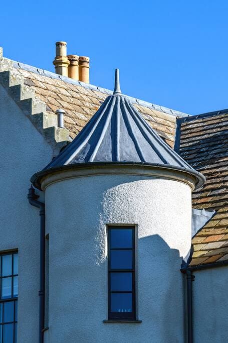 The house is built in the Scottish baronial style with turrets and crow-stepped gables