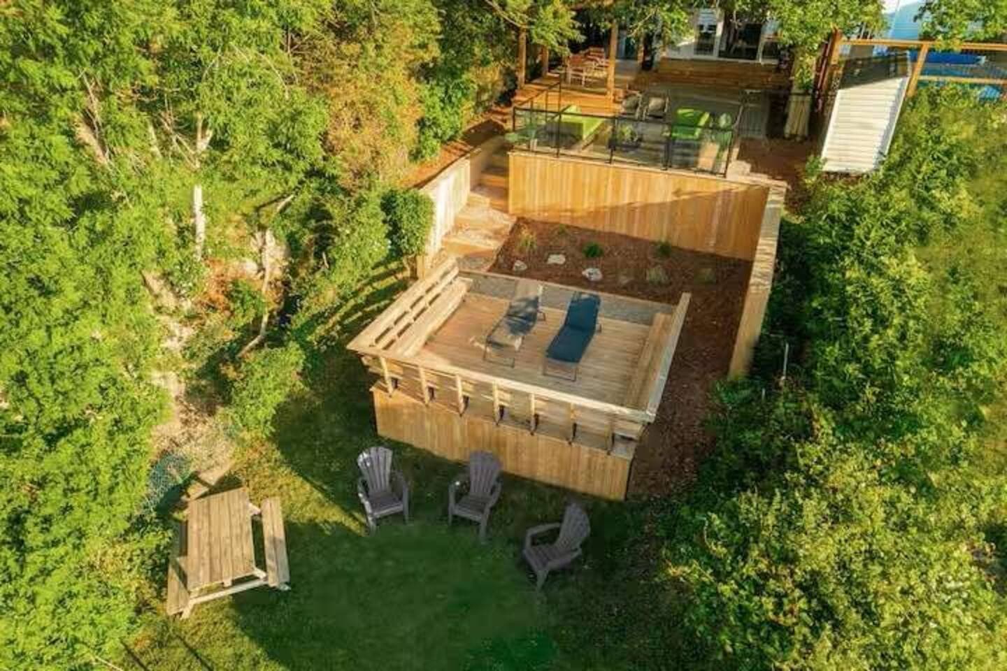An aerial view of your private, multi-level lakeside retreat — complete with decks, lounge areas, fire seating, and direct access to the water.