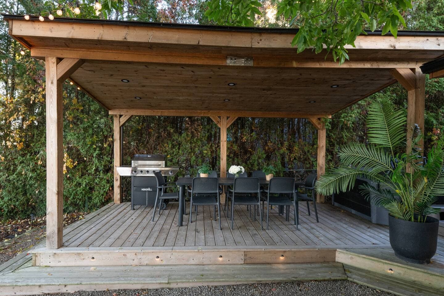 Enjoy outdoor meals under the covered pergola, complete with a full dining table, BBQ, and soft lighting — perfect for long summer dinners or cozy fall nights