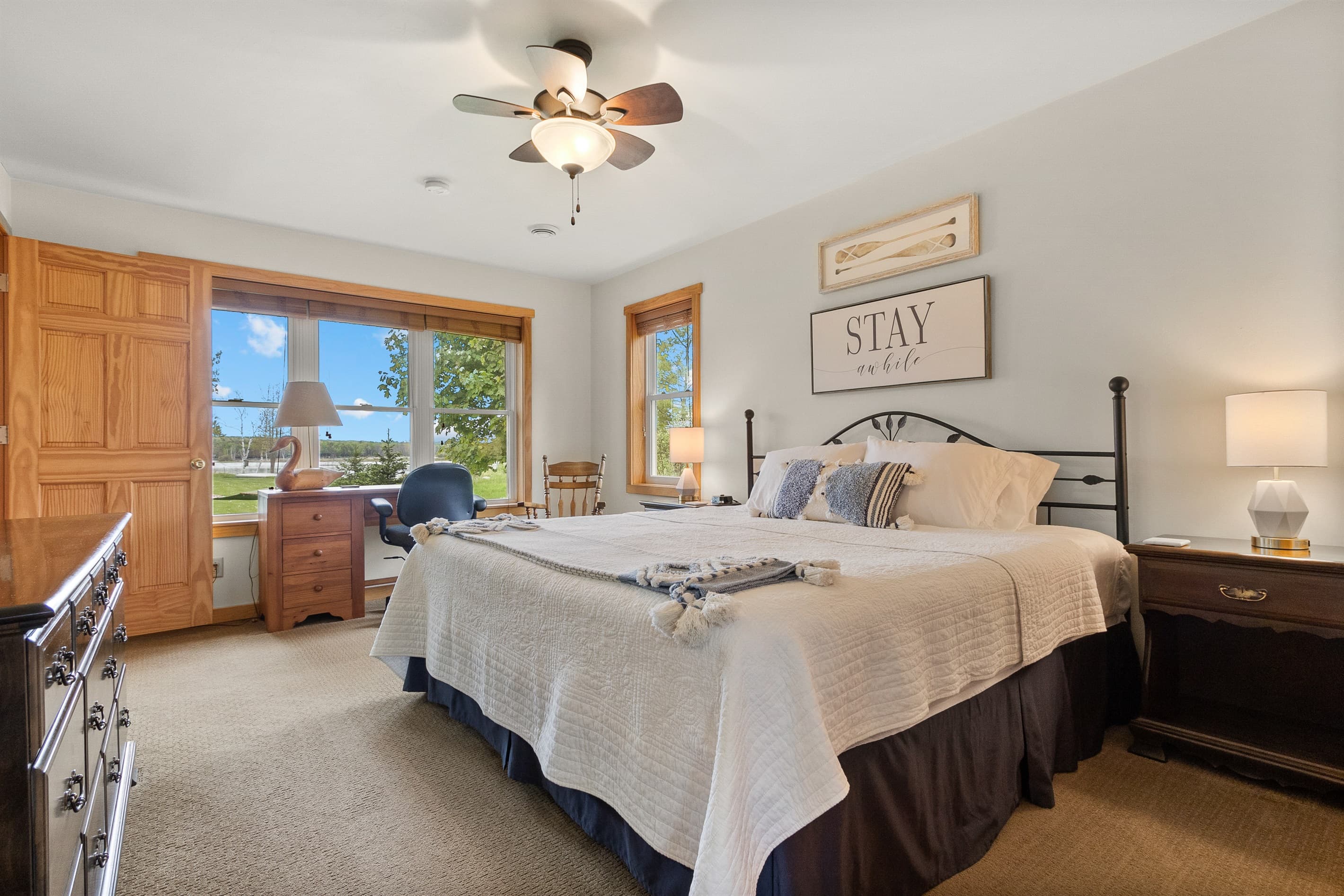 The main floor king bedroom has a desk by the window that looks out over the yard toward Sawyer Harbor. Technically a workspace. Realistically, the best seat in the cottage for a slow morning.