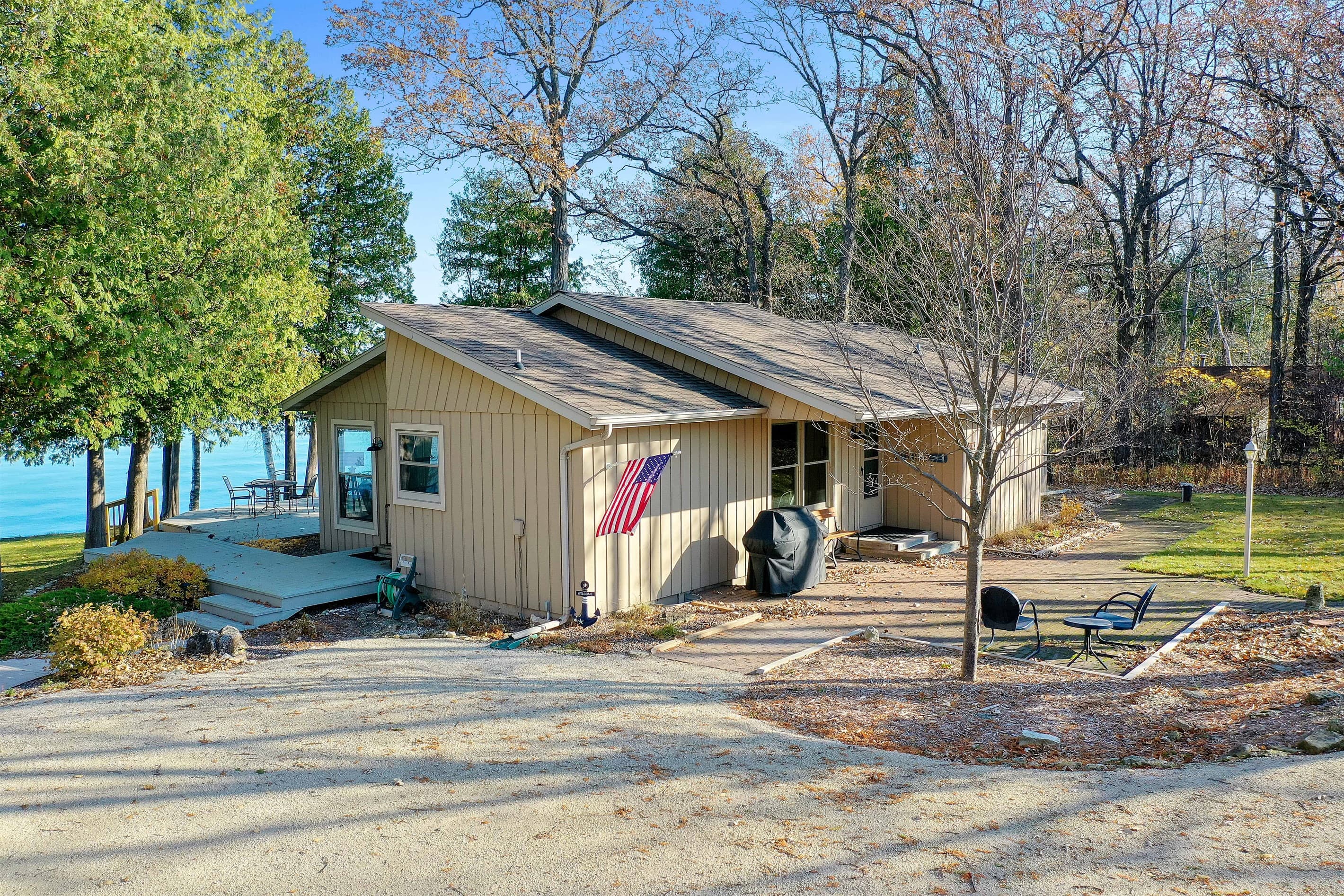 Your Door County retreat starts the moment you pull in. Vibrant fall color, a private bay peeking through the trees, and a cottage that's already beckoning you to unwind.