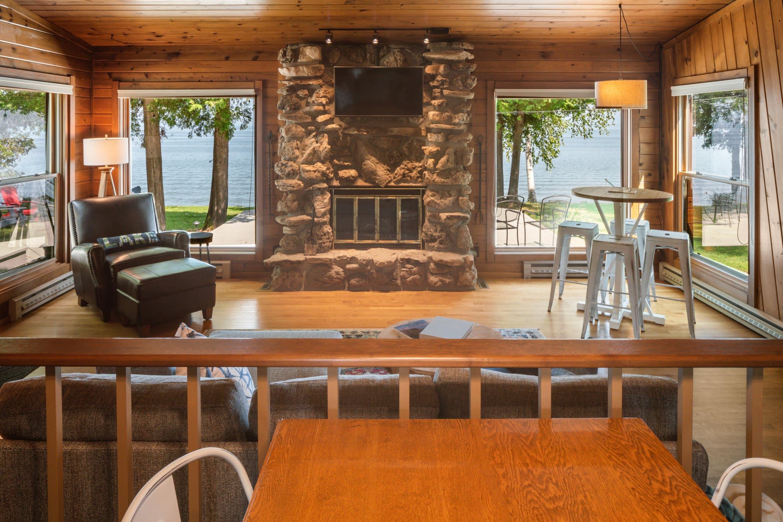As soon as you enter the cottage, you're greeted by the stunning view of the water. The large windows allow natural light to flood the space, and the Door County stone fireplace adds a warm and inviting touch.