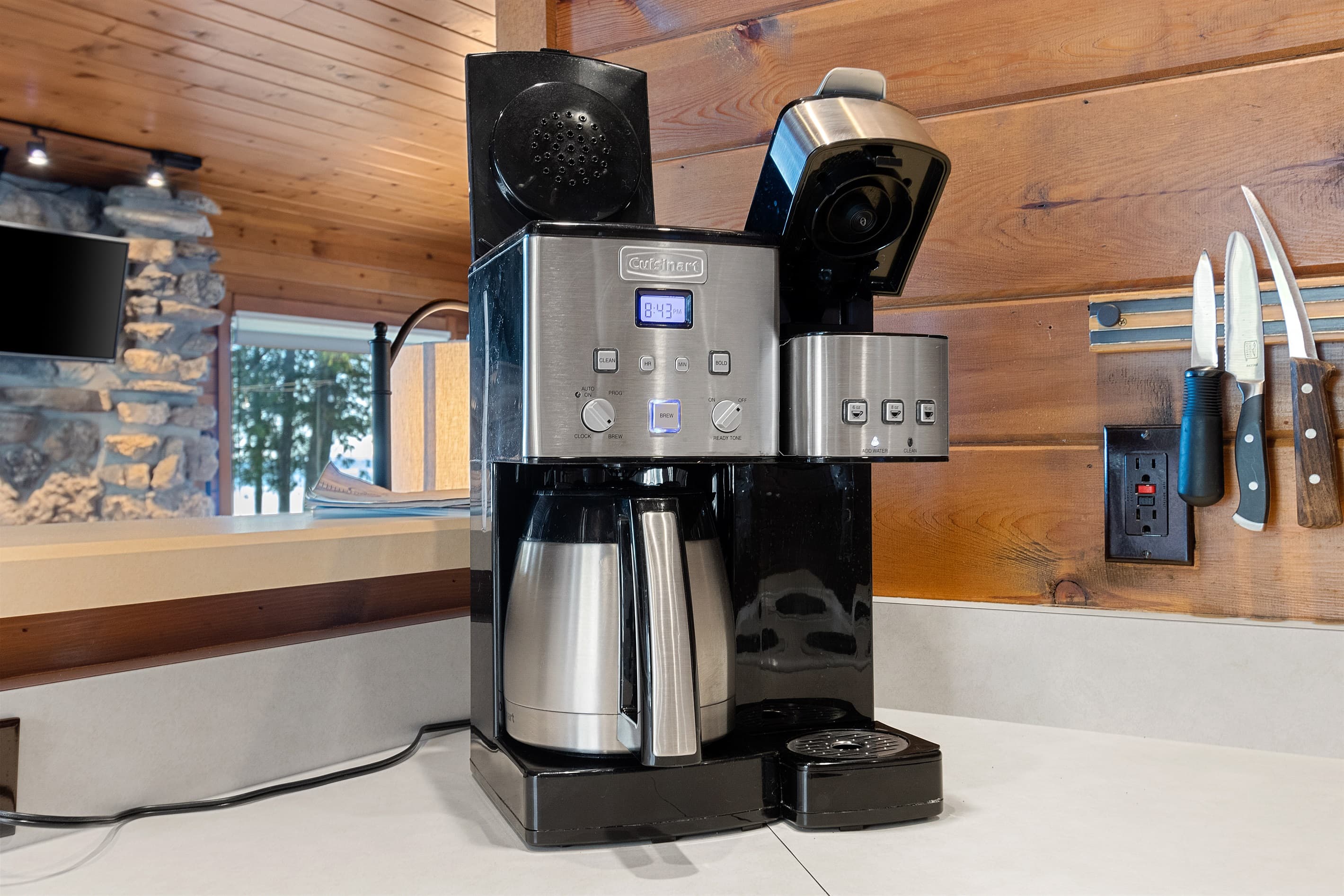 Coffee, your way — drip or single-serve — with the stone fireplace glowing in the background and the bay just past the window. Door County mornings don't get better than this.