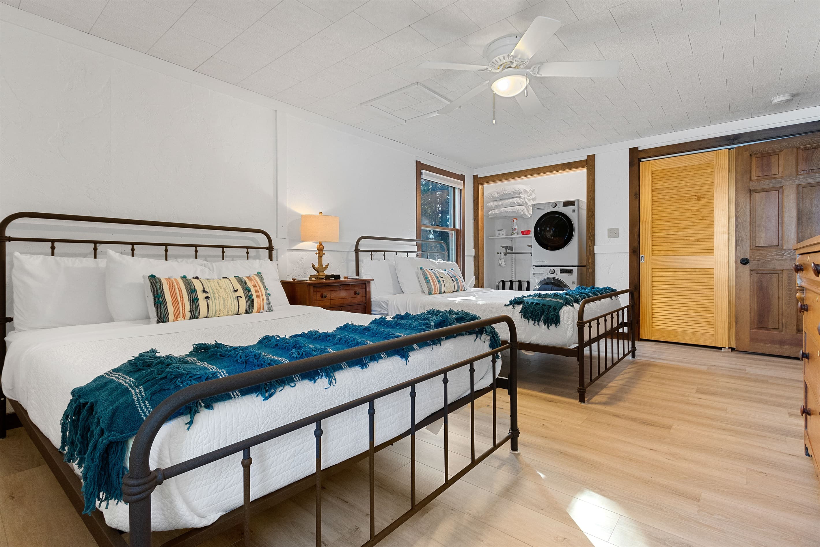 The blue throws, the anchor lamp, the painting of boats on the wall — this room has a point of view. Someone thought carefully about what it should feel like to stay here.