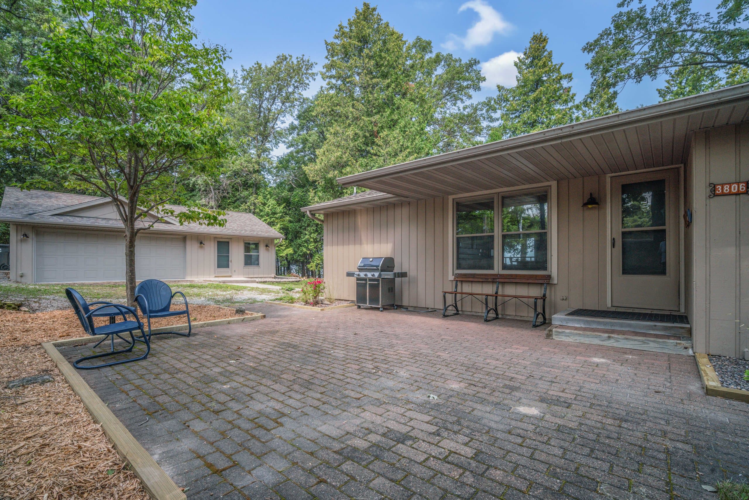 Drop your bags, step outside, and realize you're fifty feet from the bay. The covered entry, grill, and paver patio make this feel less like a rental and more like yours.