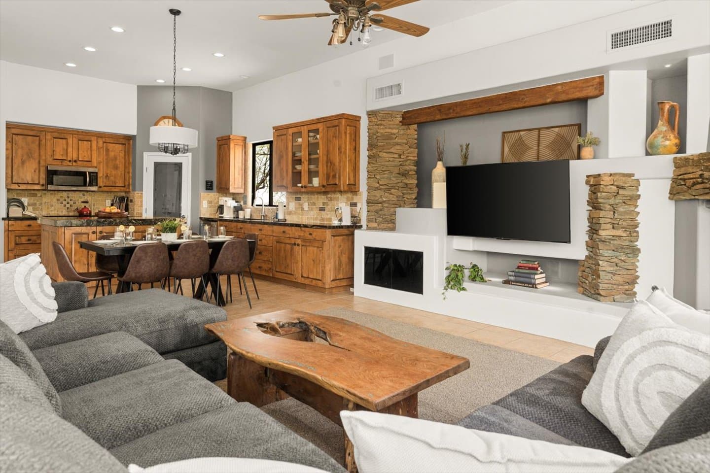 Relax in the spacious great room, featuring a plush sectional perfect gathering with family and friends. Enjoy stunning views through the huge windows that bring the beauty of the outdoors in.