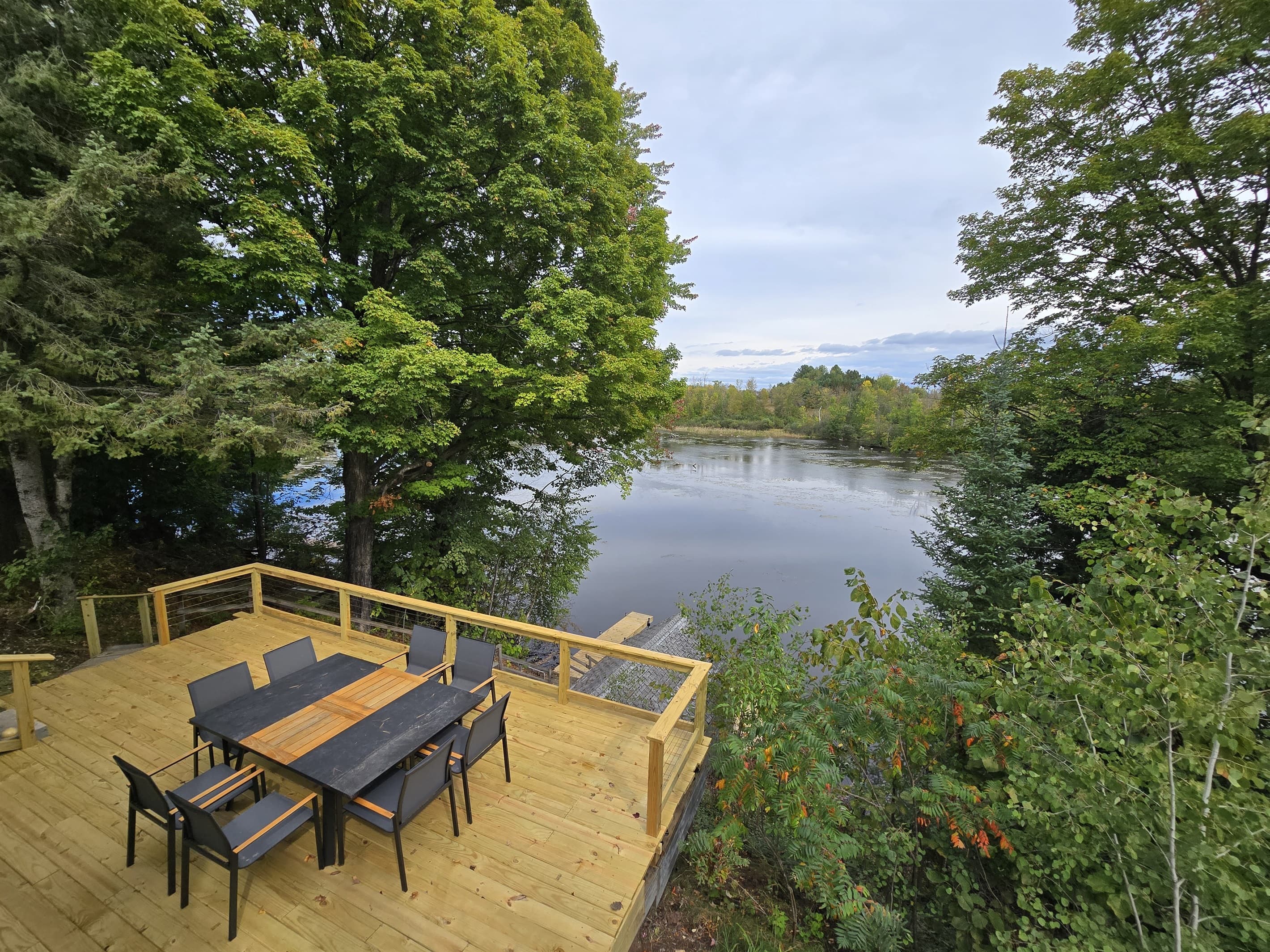 - Elevated deck dining overlooking quiet lake views   - Surrounded by lush trees for relaxing outdoor moments   - A perfect spot for meals, morning coffee, and sunsets