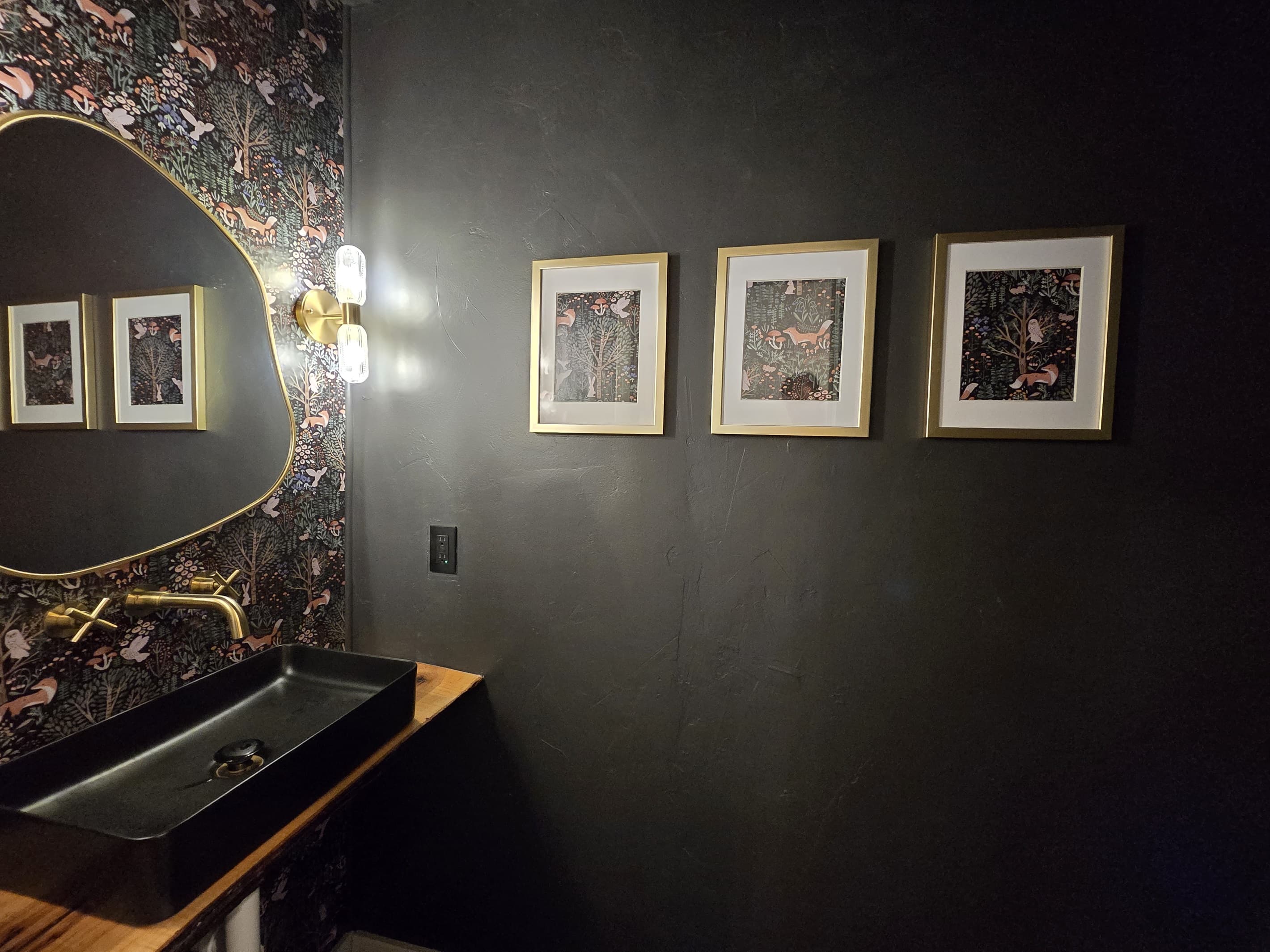 - Stylish dark bathroom with bold wallpaper detail   - Gold accents and modern lighting create warm character   - A unique designer space adding charm to your stay