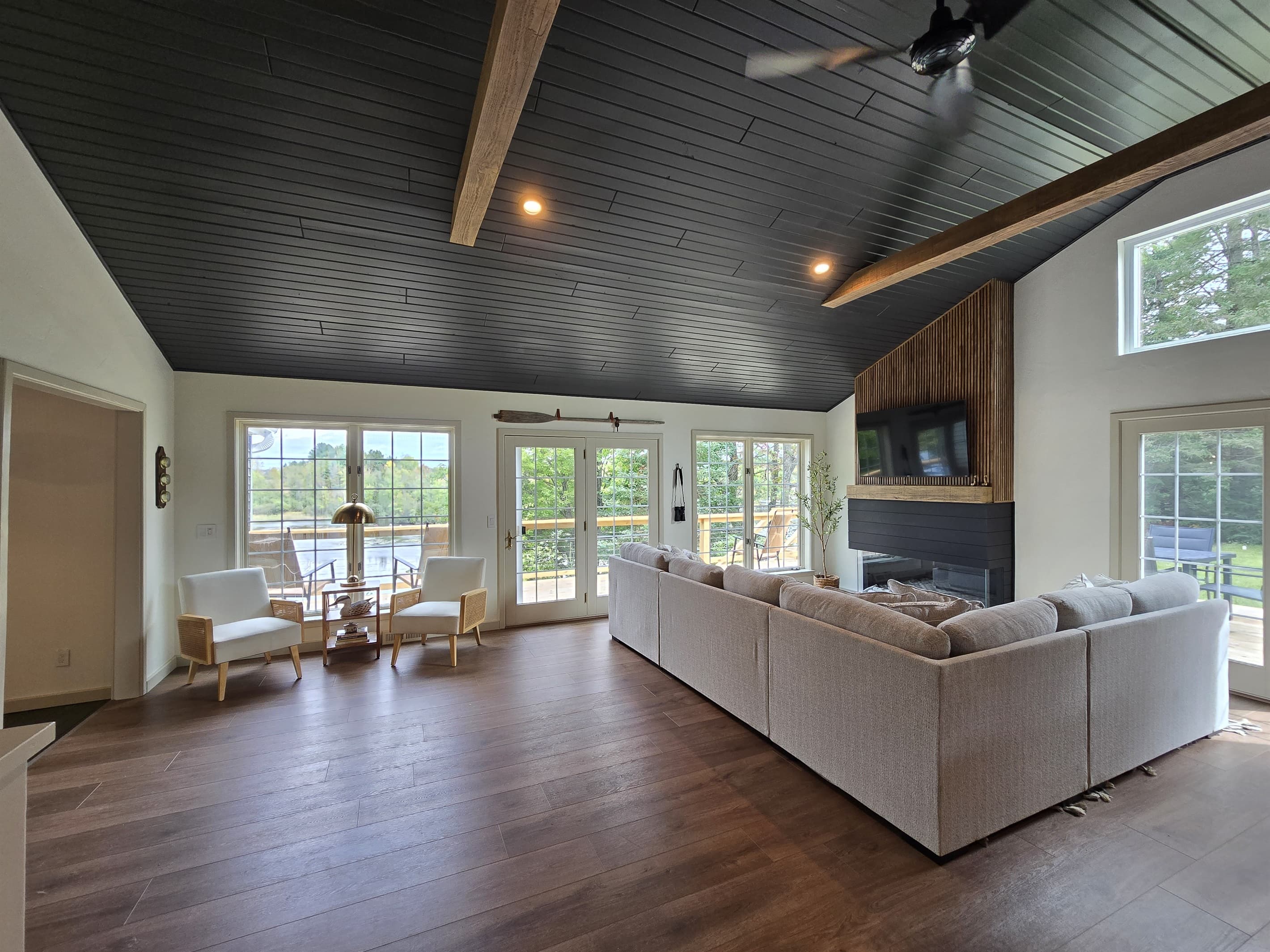 - Bright living room with tall windows and lake views   - Spacious seating centered around the fireplace   - Open layout perfect for gatherings and relaxation