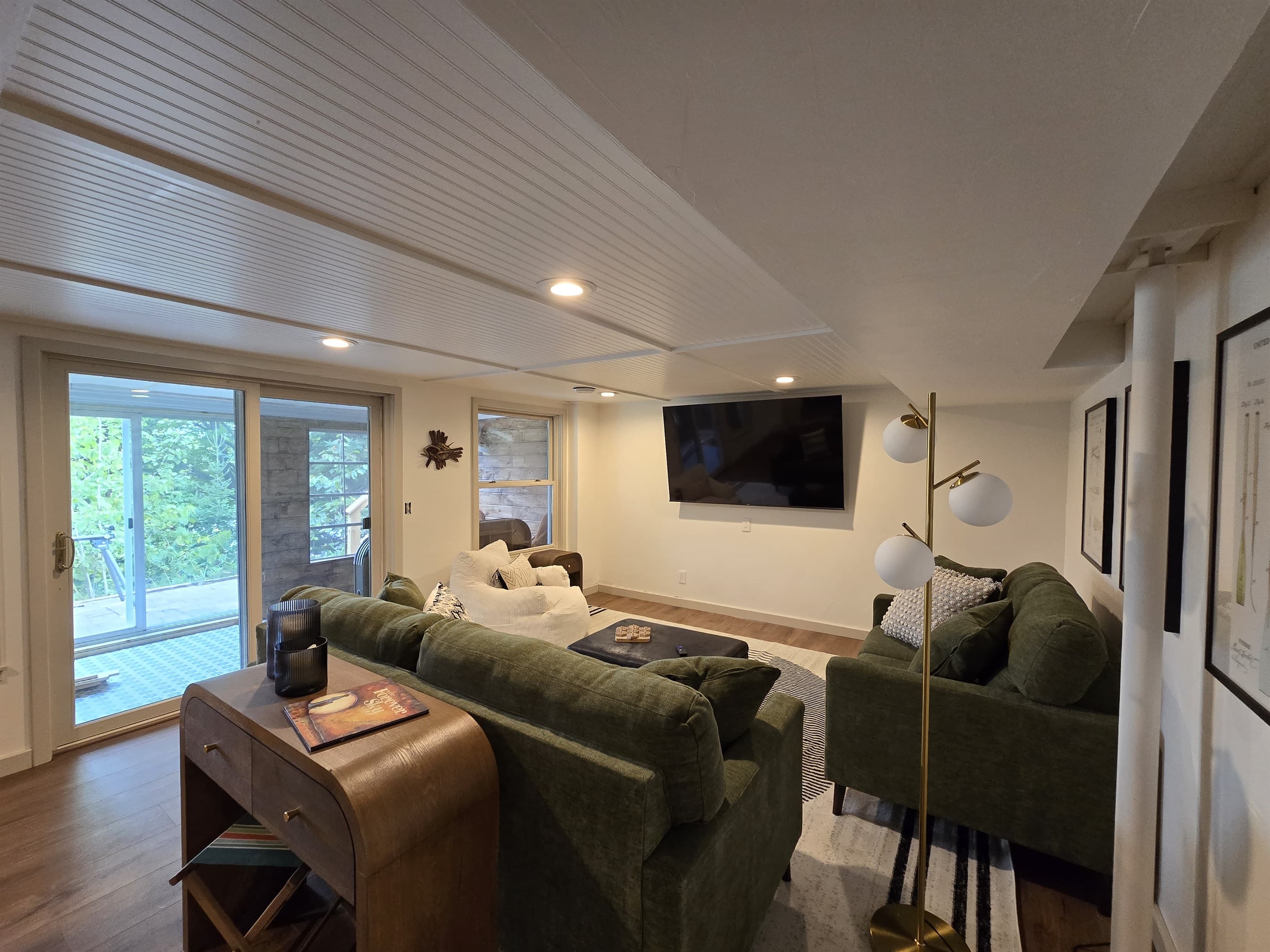- Cozy living room with plush seating and large TV   - Sliding doors bring in fresh light and outdoor views   - Relaxed downstairs hangout for movie nights