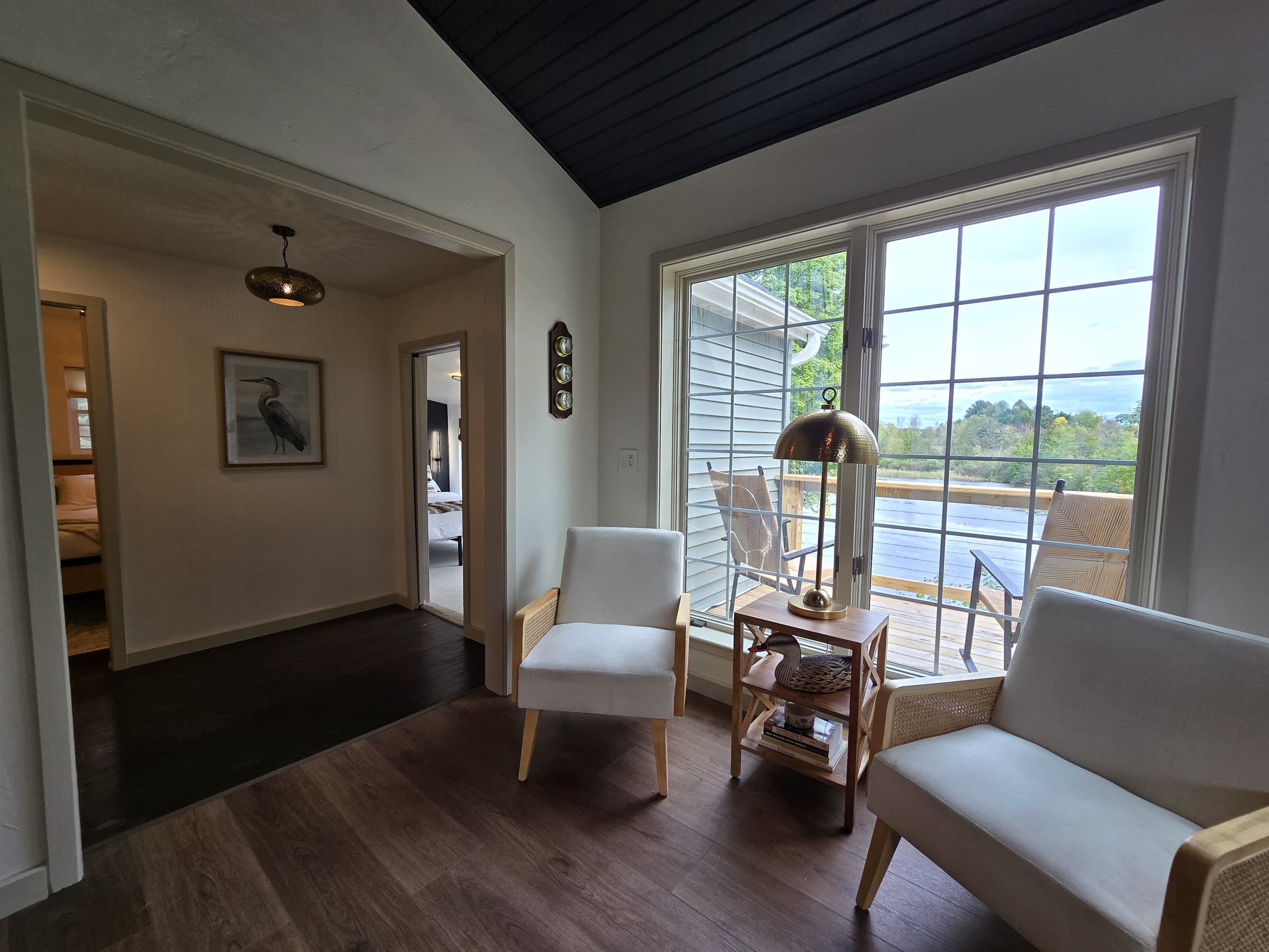 - Bright sitting corner with chairs and lake backdrop   - Natural light fills this inviting indoor lounge   - Perfect space for reading relaxing and enjoying views