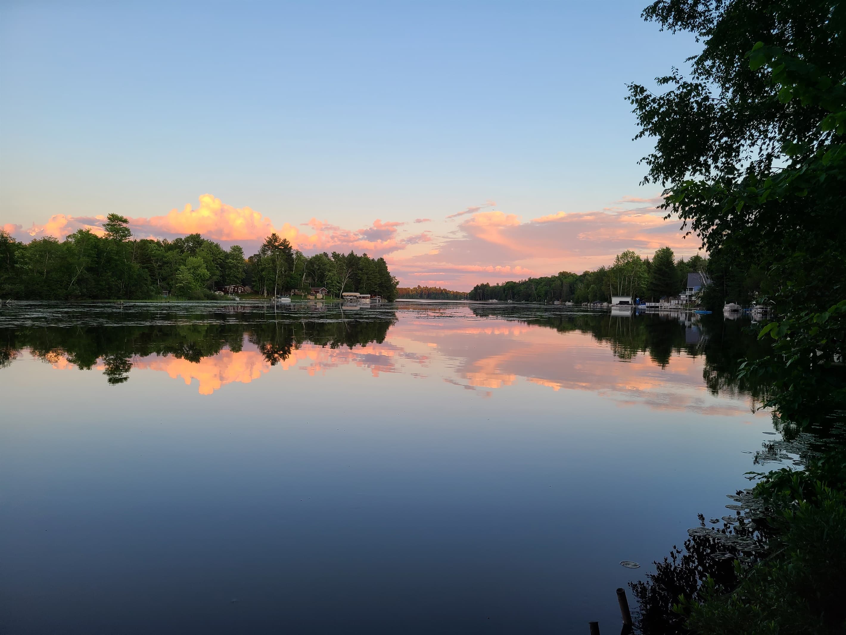 - Calm lake view with sunset clouds reflecting softly   - Peaceful colors create a dreamy waterfront moment   - Ideal setting for evening relaxation by the water