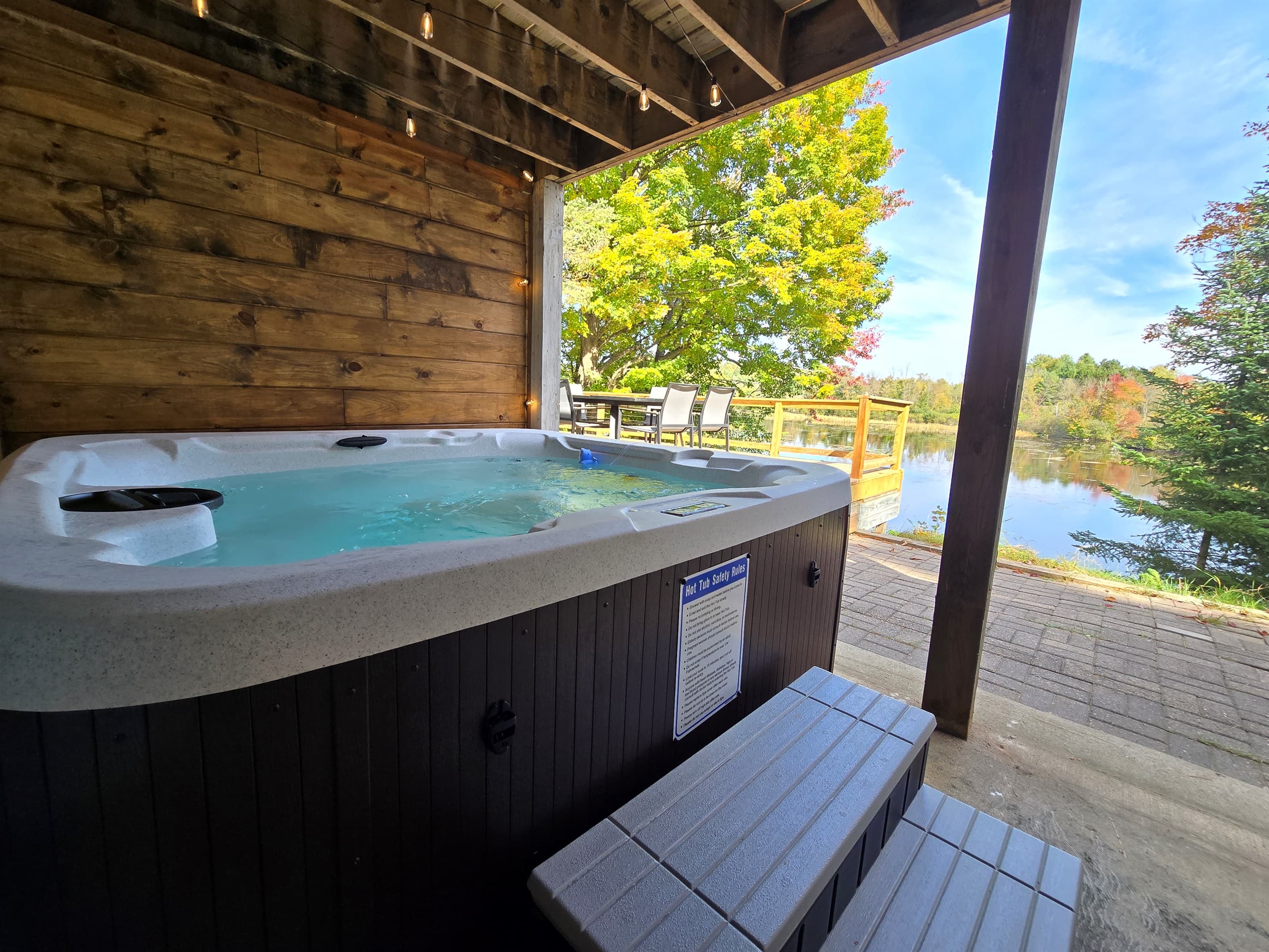 - Relax in the warm hot tub with peaceful lake views   - Covered patio lets you soak in comfort year round   - A quiet retreat surrounded by nature and calm water