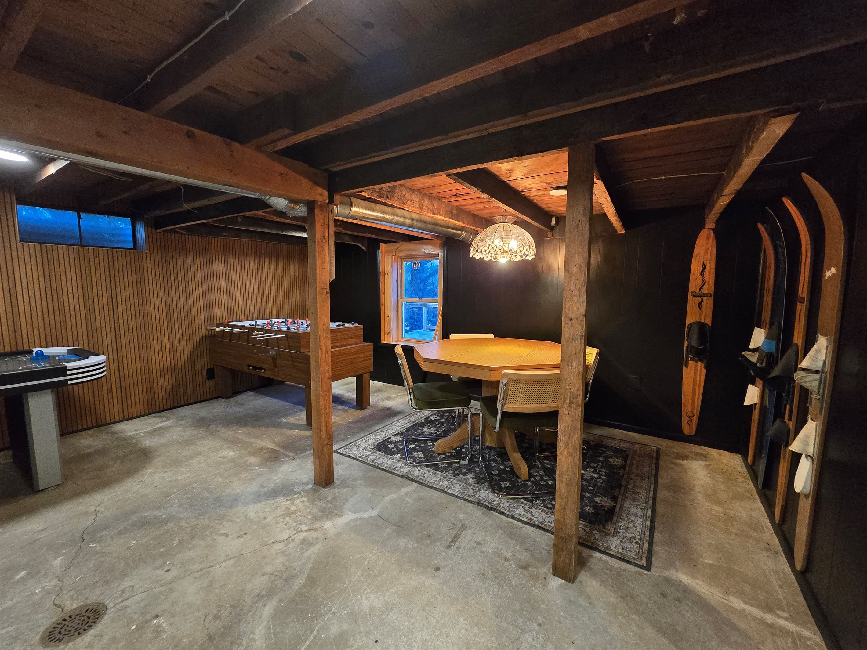 - Fun game room with foosball and card table setup   - Wood beams and warm lighting create a cozy vibe   - Perfect hangout spot for friendly competition