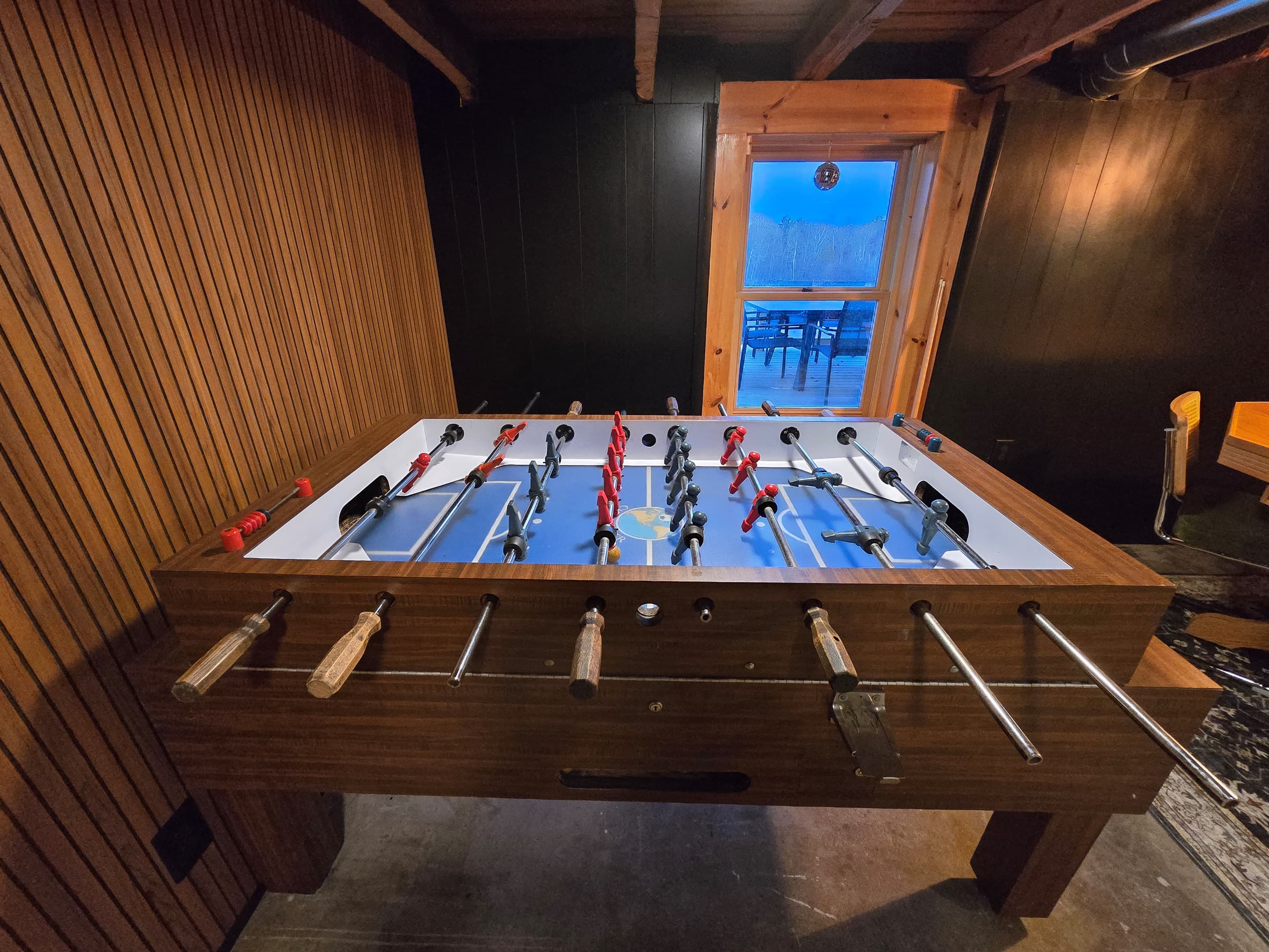 - Foosball table set in a cozy rustic game room   - Natural wood accents make playtime inviting   - Fun competitive space for friends and family