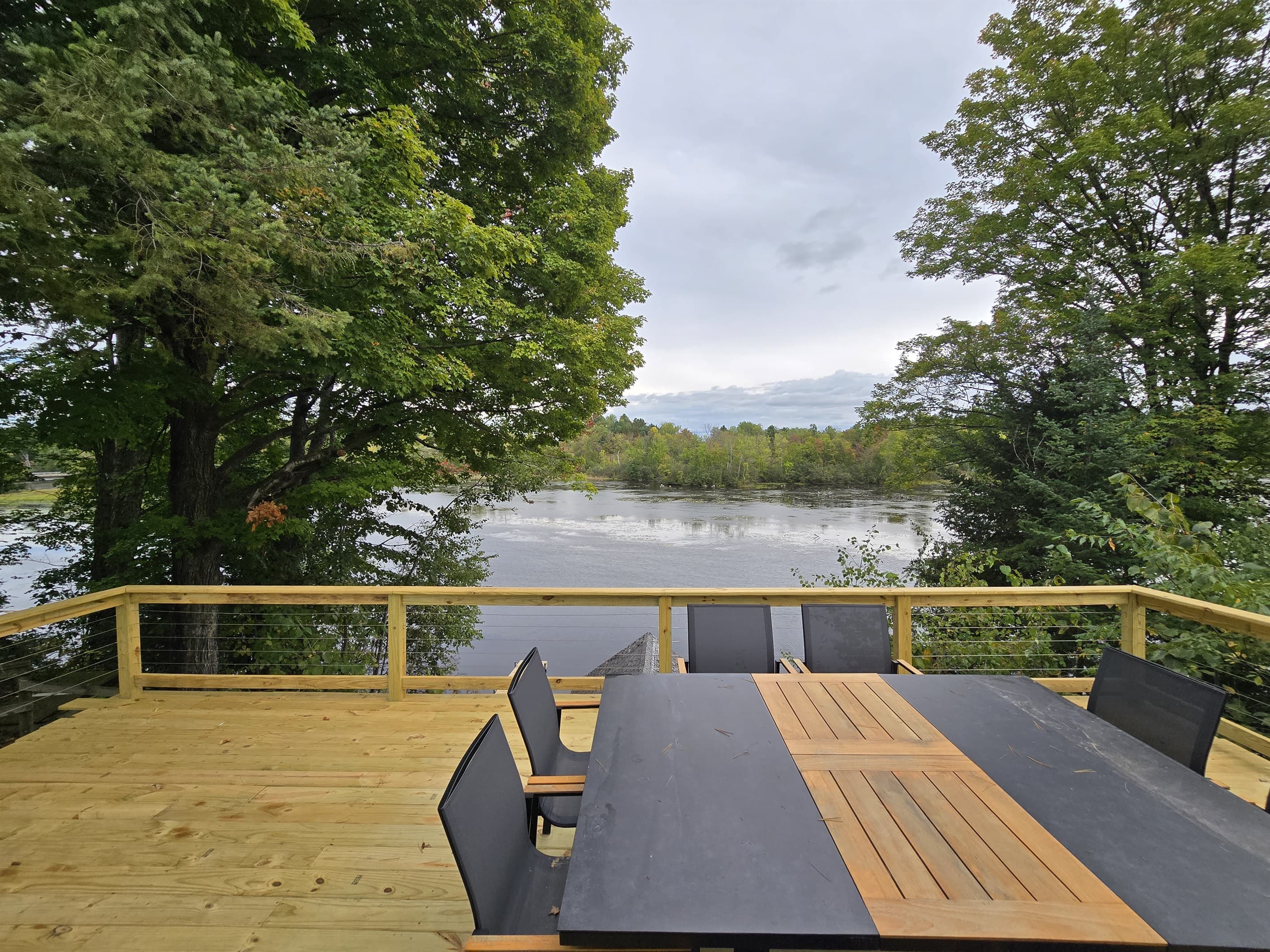 - Scenic dining deck with peaceful lake views   - Surrounded by tall trees for quiet outdoor meals   - Ideal spot for coffee gatherings and sunsets