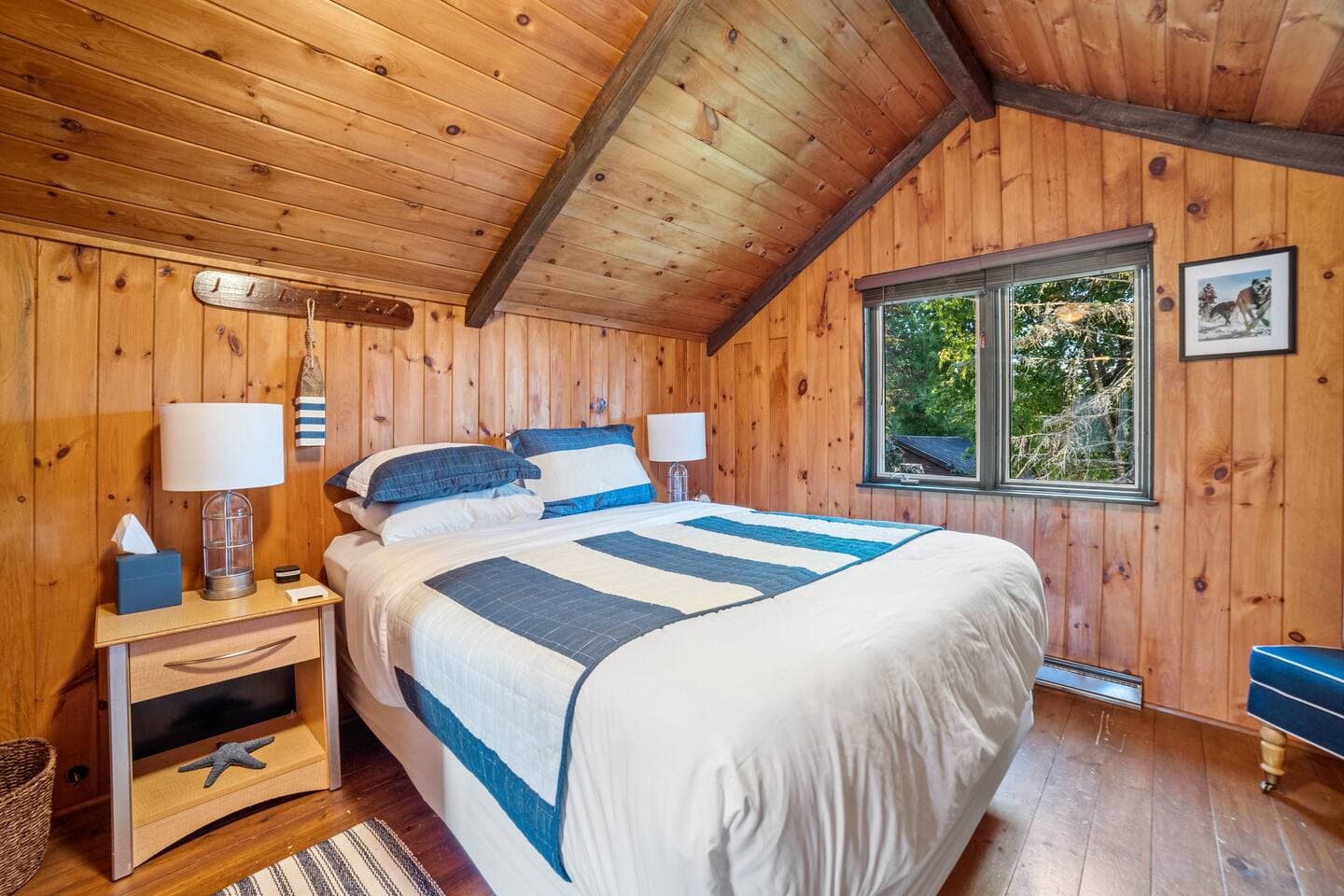 You have arrived up North, the entire upstairs is  covered with knotty pine! Both bedrooms have high ceilings with a fan.  This is a queen bed with a foam topper and luxury linens. 