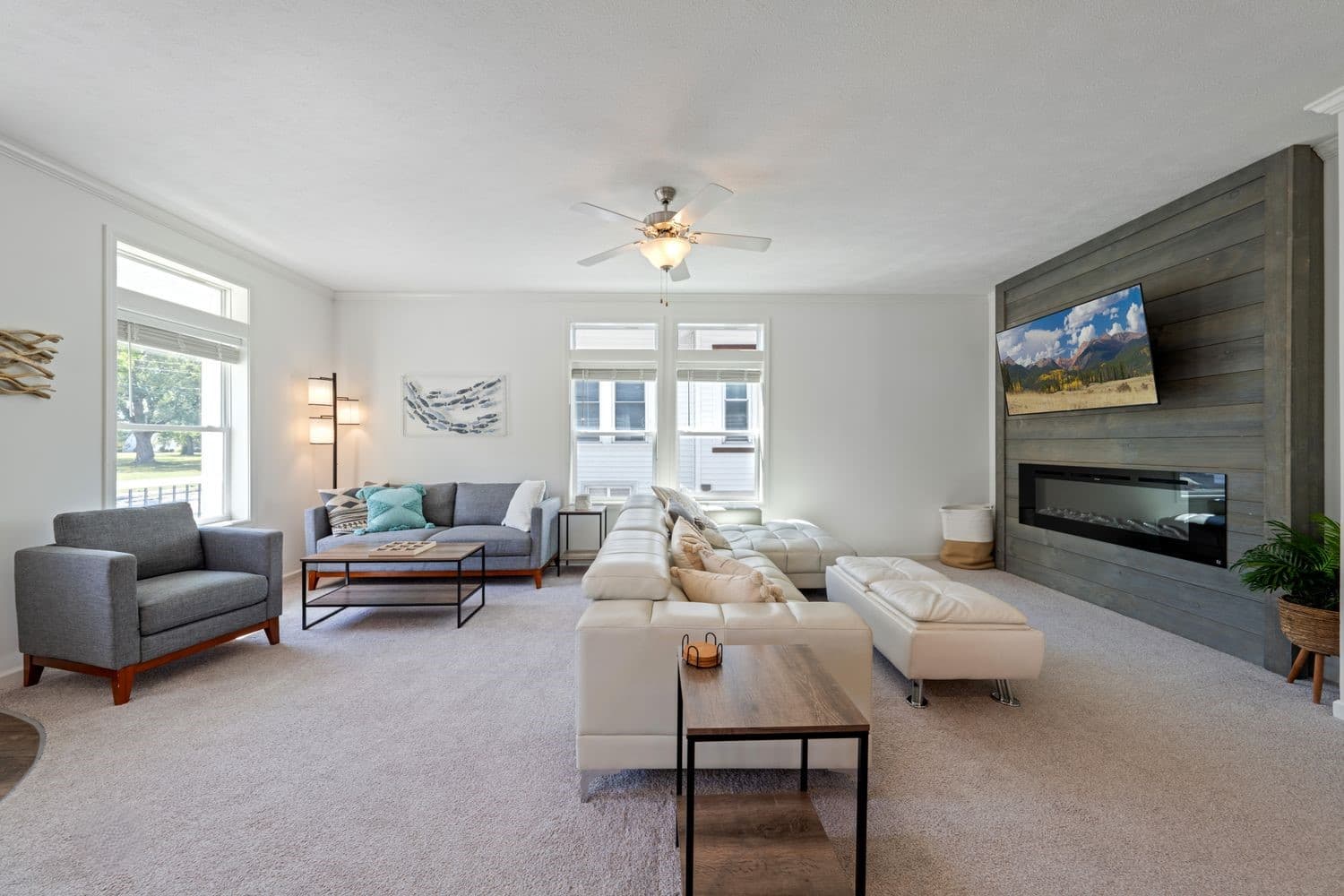 Large living room with plenty of seating, electric fireplace and large smart TV