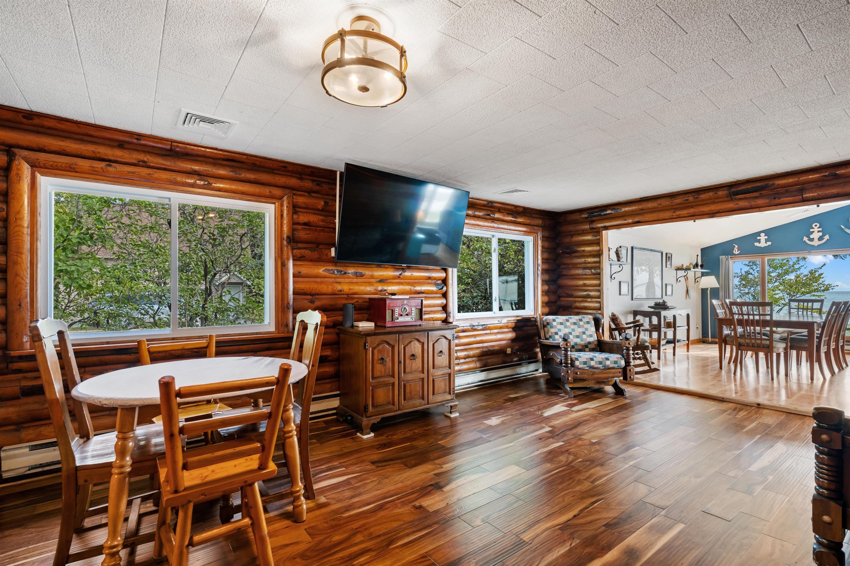 The Log room with brand new windows to enjoy the view and breeze A brand new queen sized Ashley sleeper sofa is in this area.