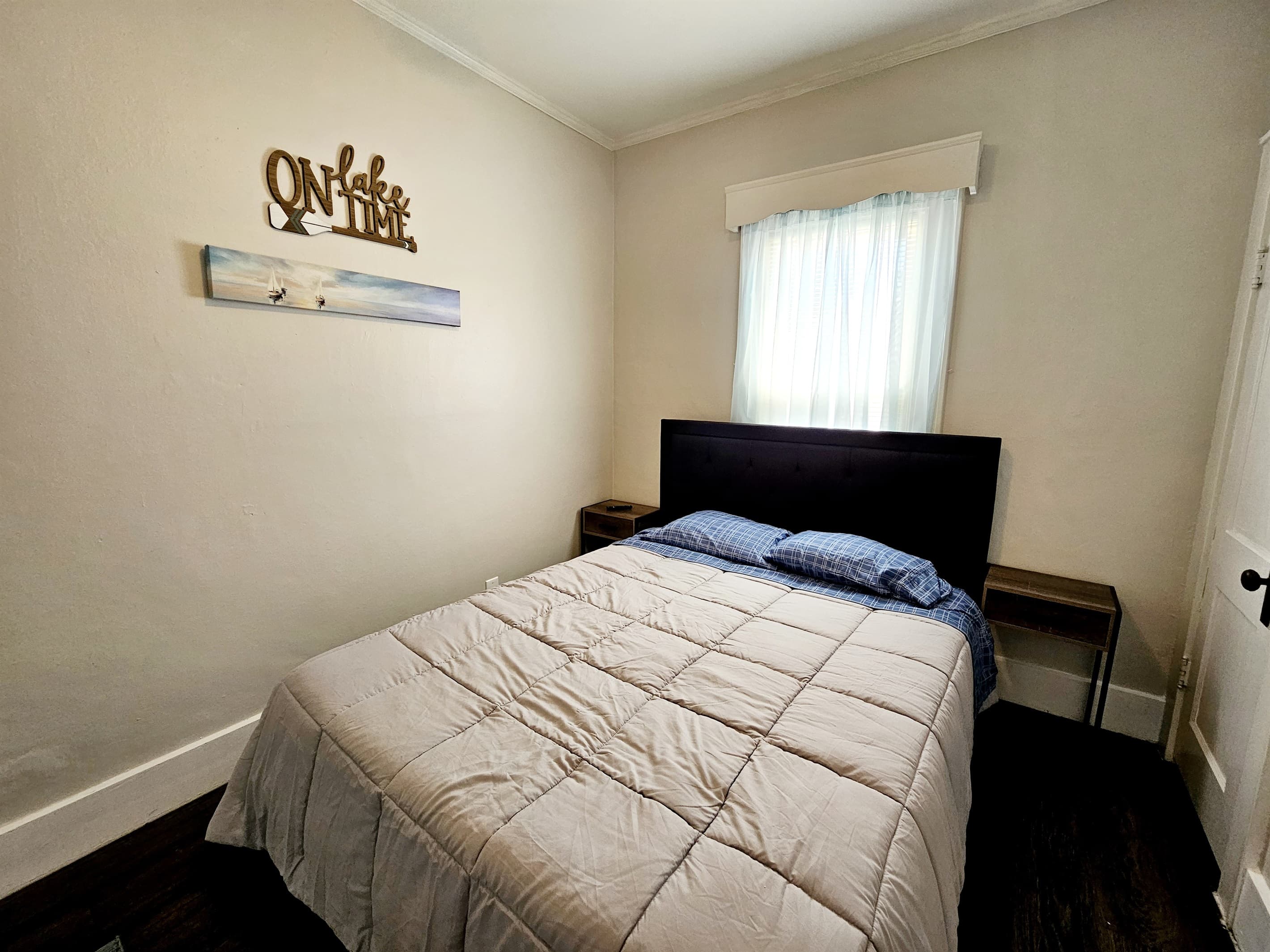 Bedroom 2 with a queen sized bed and a wall mounted 32" smart TV