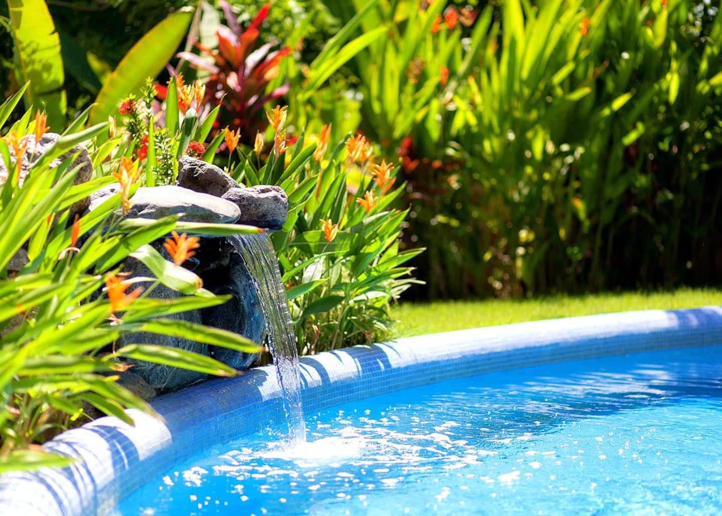 Waterfall and colorful landscaping decorate the heated pool.