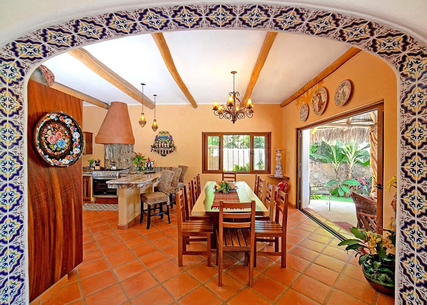 Full kitchen and dining room with open air doors leading to the private pool.