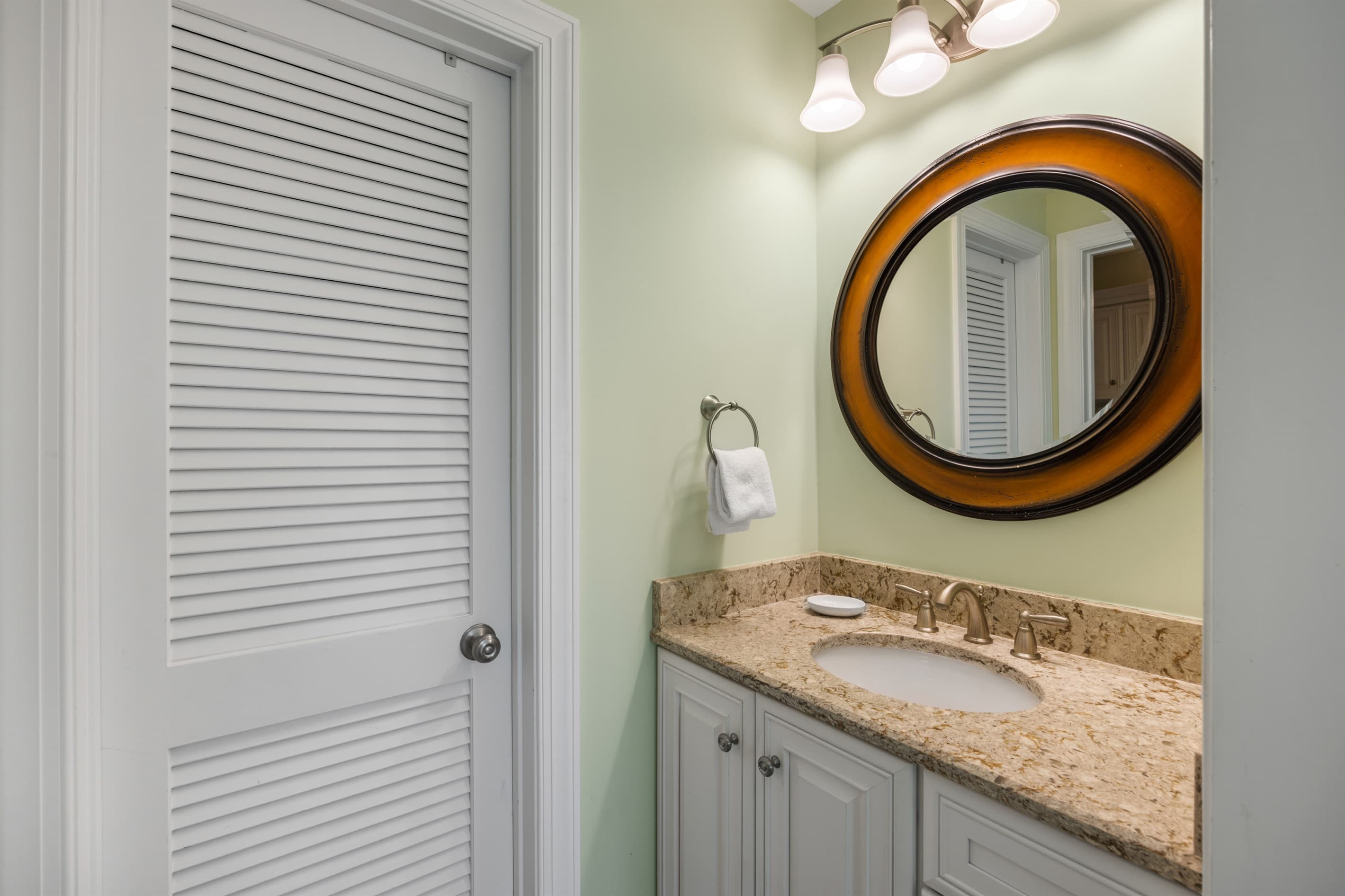 Stylish bath w/ warm lighting & clean finishes.