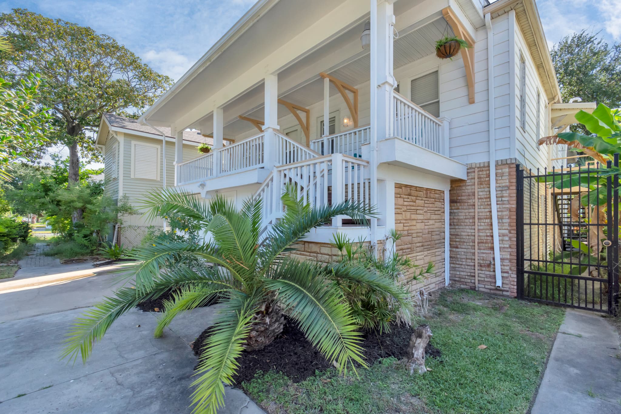The charming covered porch of the Historic Anchor at M — a quintessential Galveston welcome waiting every time you return home from the beach.