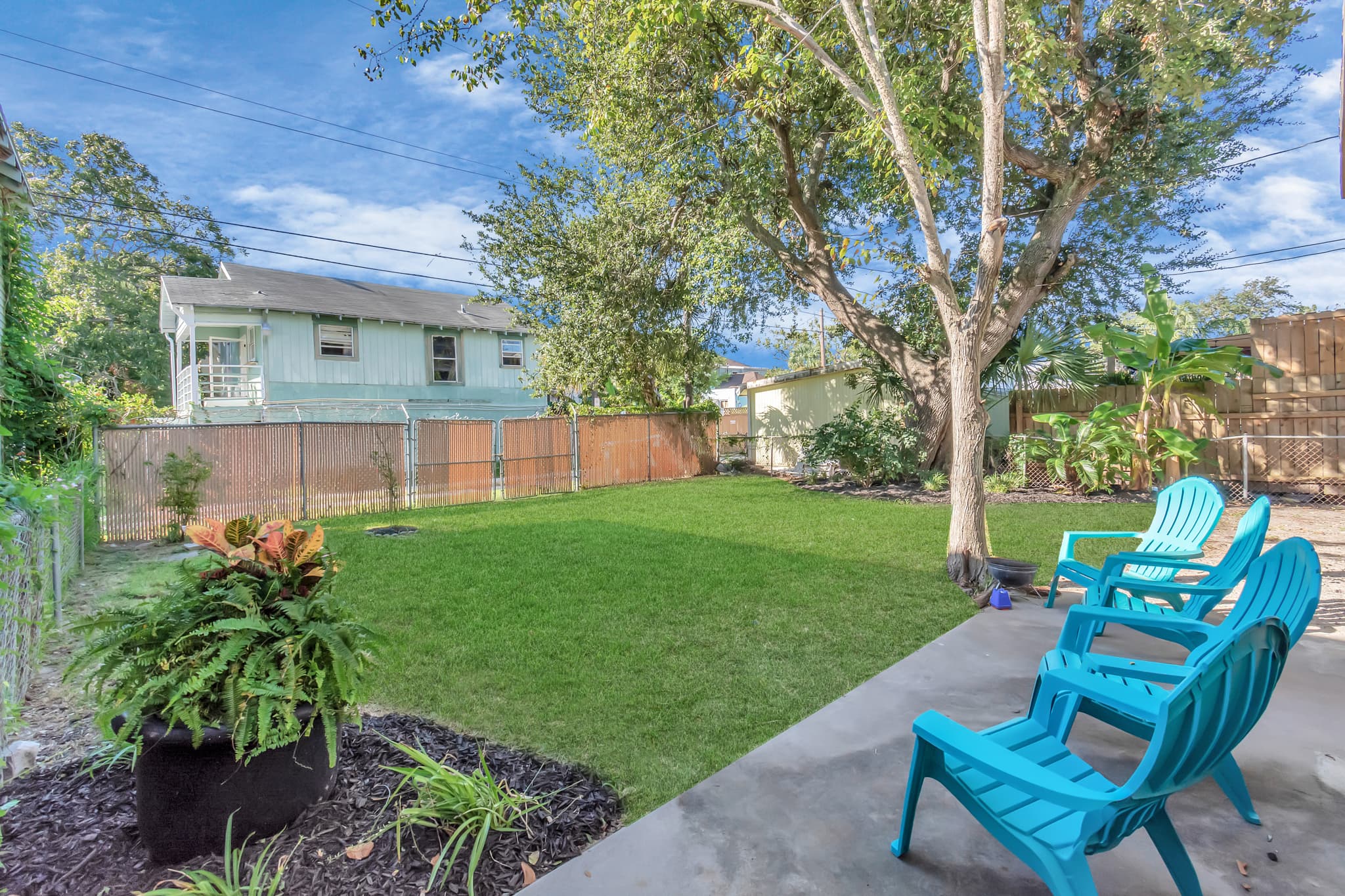 The shared backyard at 1705 Avenue M offers a lush, shaded retreat — the perfect place to unwind after a day at the beach or exploring the island.