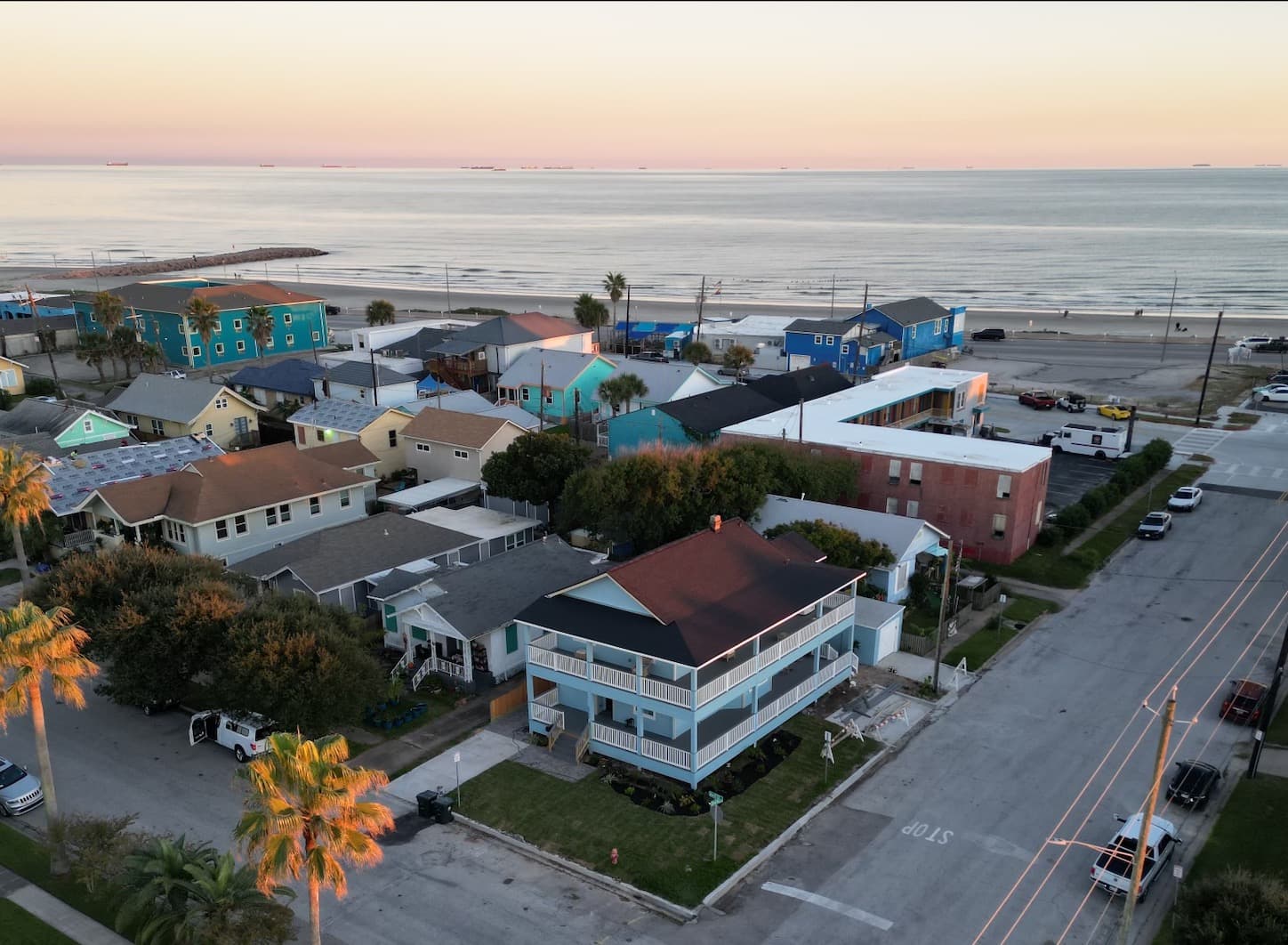The Lookout at R½ on the Galveston Seawall — the beach is a 2-minute walk from your private top-floor wraparound deck. Golden hour over the Gulf.