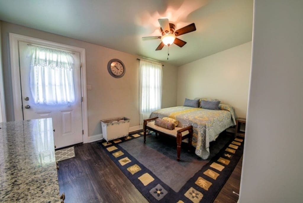 The primary bedroom features a comfortable queen bed and a private en-suite bath, with a door leading right out to the backyard.